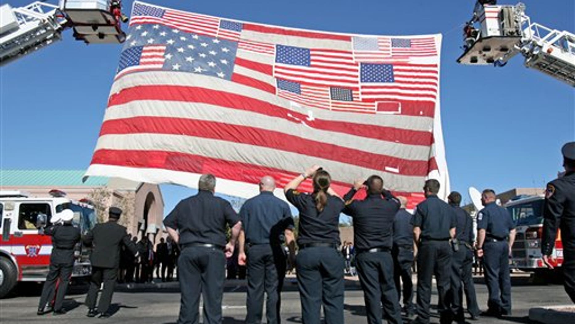 Jan. 13, 2011: Firefighters raise the large American flag recovered from Ground Zero after the 9/11 attacks outside the entrance at the St. Elizabeth Ann Seton Church for the funeral of 9-year-old Christina Taylor Green in Tucson, Ariz. Green, the youngest victim of Saturday's shooting in Tucson, was born on the day of the Sept. 11 attacks in 2001.