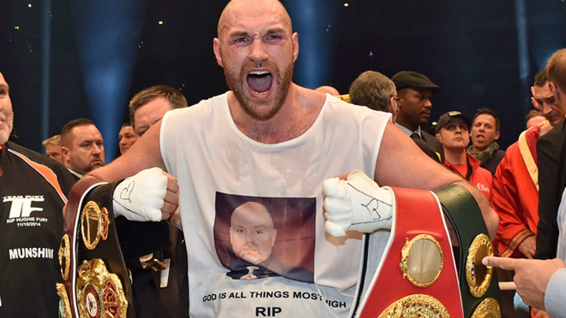 In this Nov. 29, 2015 file photo, Britain's new world champion Tyson Fury, celebrates with the WBA, IBF, WBO and IBO belts after winning the world heavyweight title fight against Ukraine's Wladimir Klitschko in Duesseldorf, western Germany.