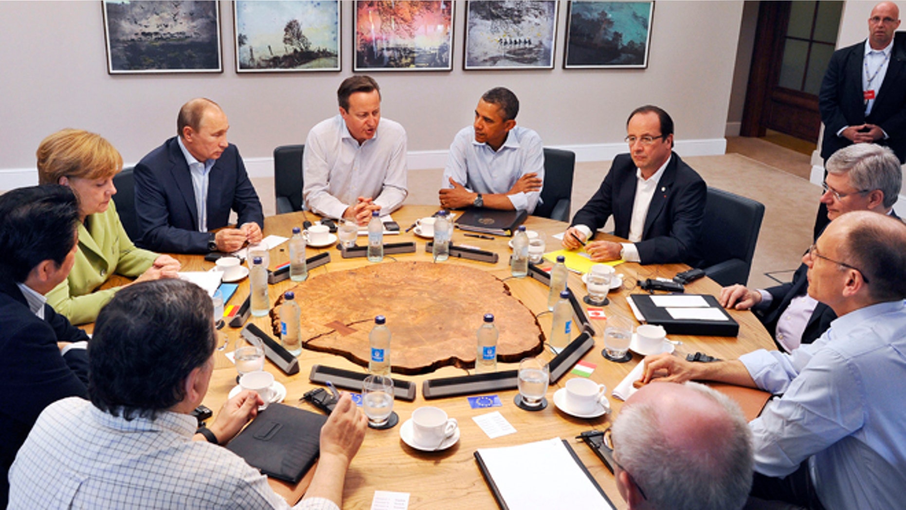 June 18, 2013: G8 leaders from left, European Commission President Jose Manuel Barroso, Japan's Prime Minister Shinzo Abe, German Chancellor Angela Merkel, Russian President Vladimir Putin, Britain's Prime Minister David Cameron, US President Barack Obama, French President Francois Hollande, Canadian Prime Minister Stephen Harper, Italian Prime Minister Enrico Letta and European Council President Herman Van Rompuy attend a working session during the G-8 summit at the Lough Erne golf resort in Enniskillen, Northern Ireland.