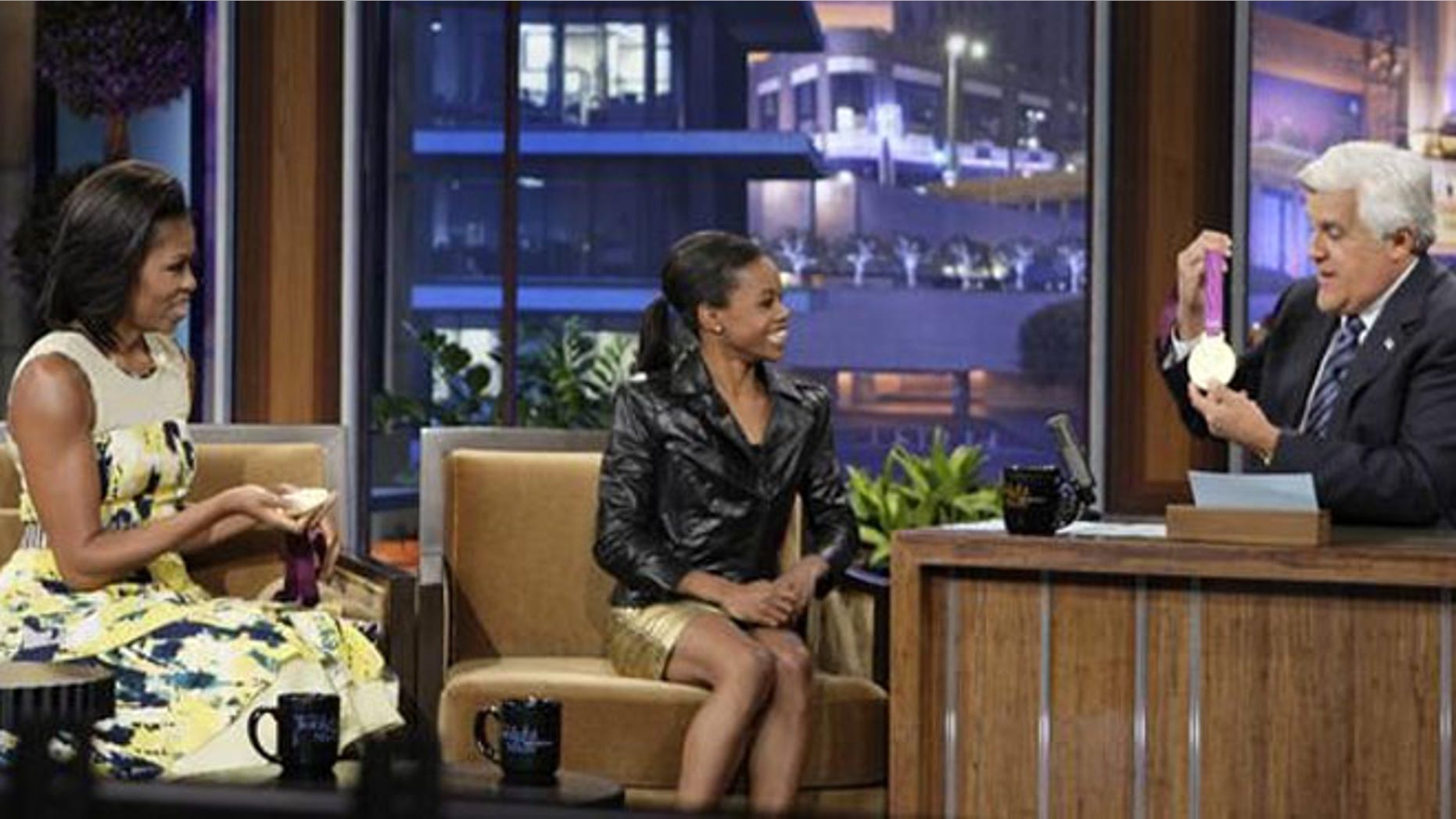 Gabby Douglas shows off her gold medals to First Lady Michelle Obama, left, and Tonight Show host Jay Leno.
