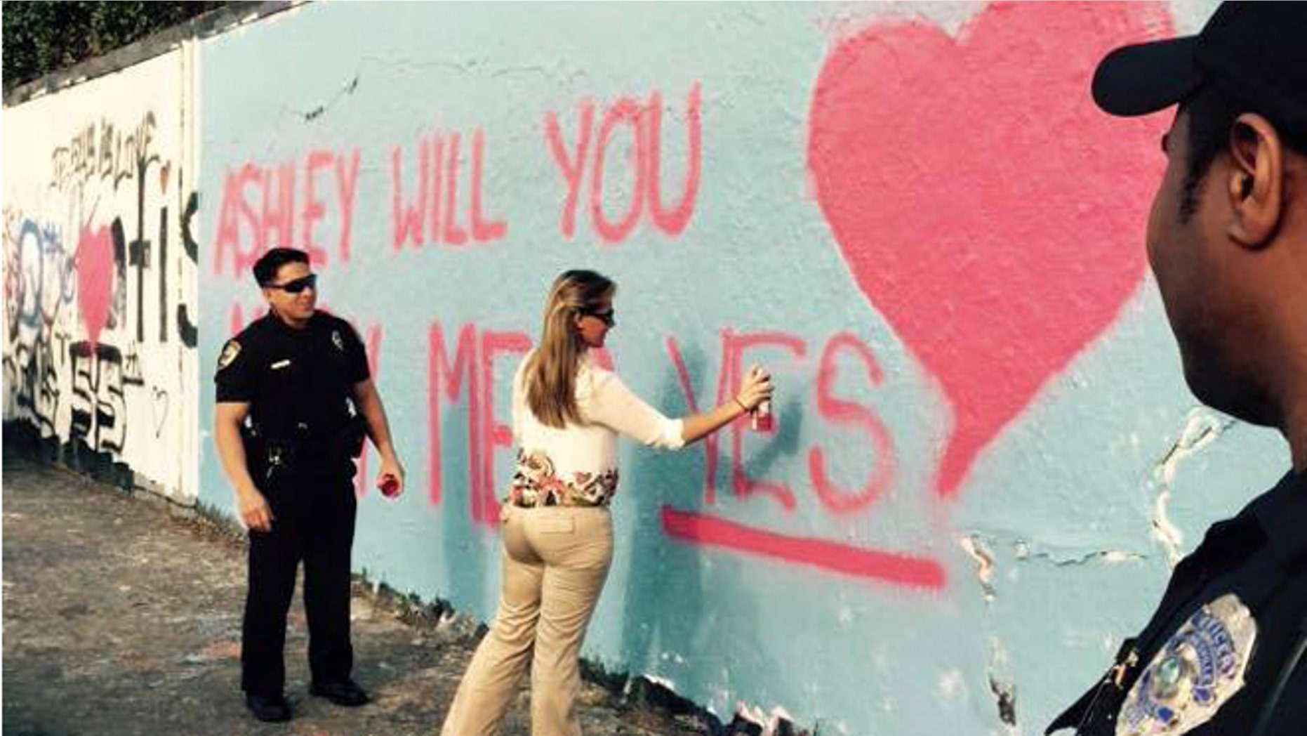 Officer Christian Hickey proposes to girlfriend Ashley Alderman at Gainesville, Fla., 34th Street graffiti wall. (Gainesville Police Department)