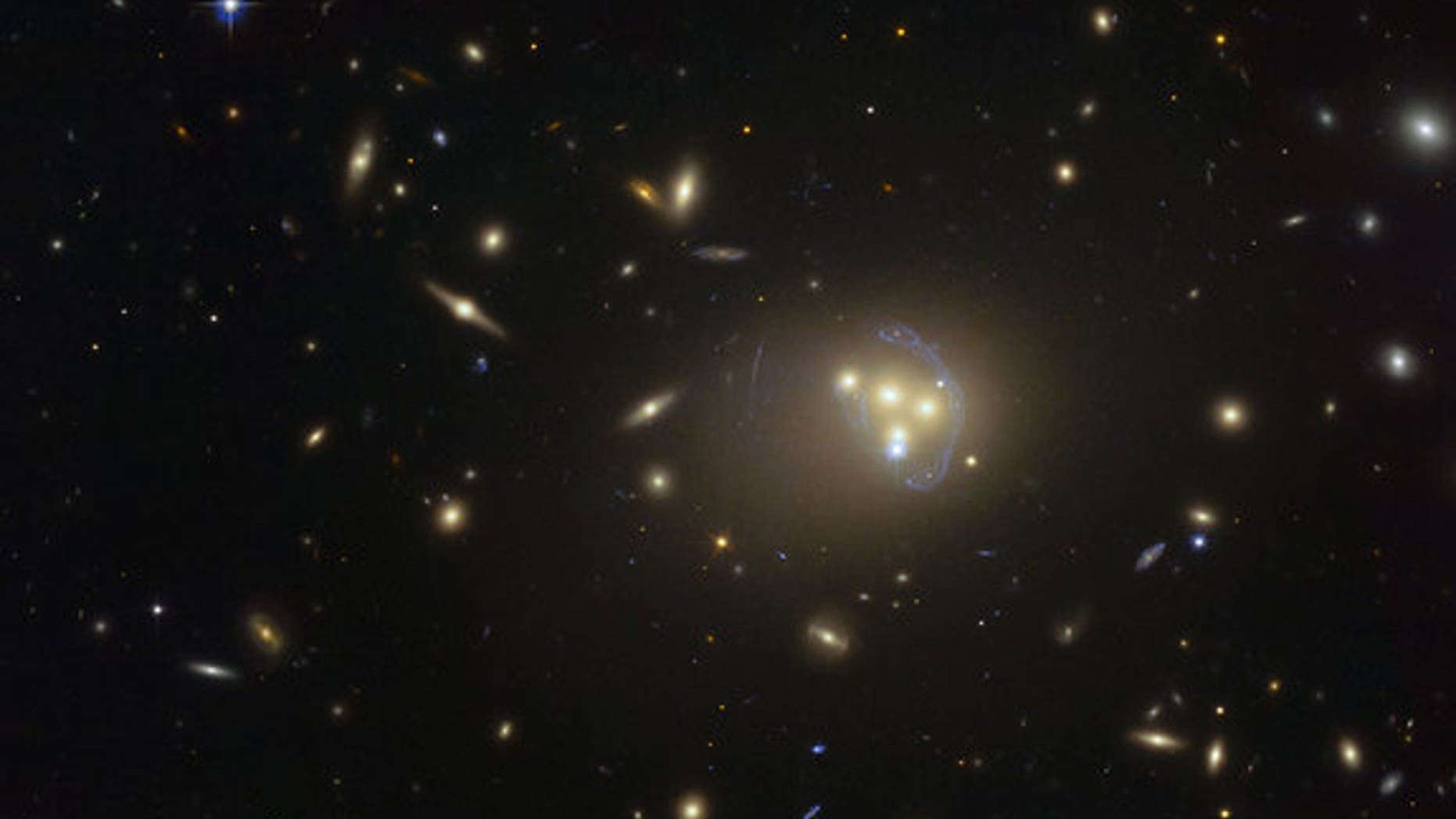 A Hubble Space Telescope image of galaxy cluster Abell 3827, where dark matter may have been observed interacting with itself during a galaxy collision.