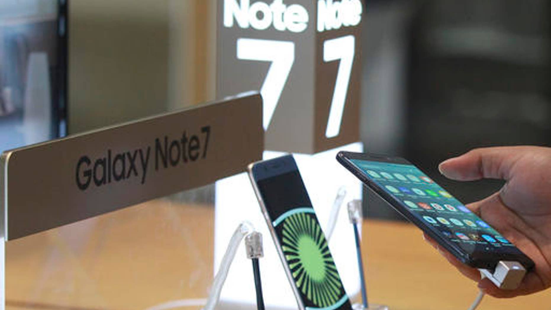 A visitor tries out a Samsung Galaxy Note 7 smartphone at a shop in Seoul, South Korea, Monday, Oct. 10, 2016.