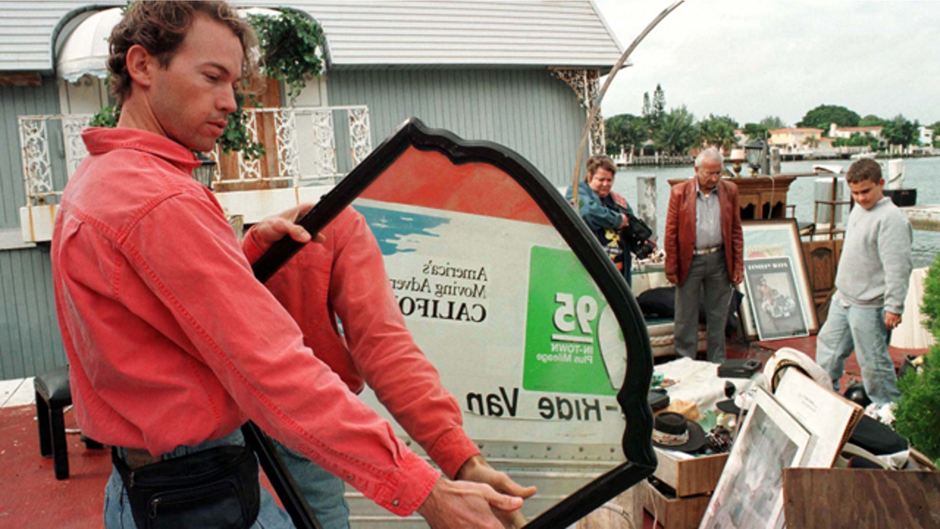 Mike Levin examines a mirror December 29 that once hung in the bedroom of the houseboat where Gianni Versace's killer, Andrew Cunanan was found dead. The owner of the famed houseboat where the serial killer committed suicide held a yard sale of household goods from the houseboat, which partially sunk seven days ago along Miami Beach's intercoastal waterways, December 29.VERSACE HOUSEBOAT