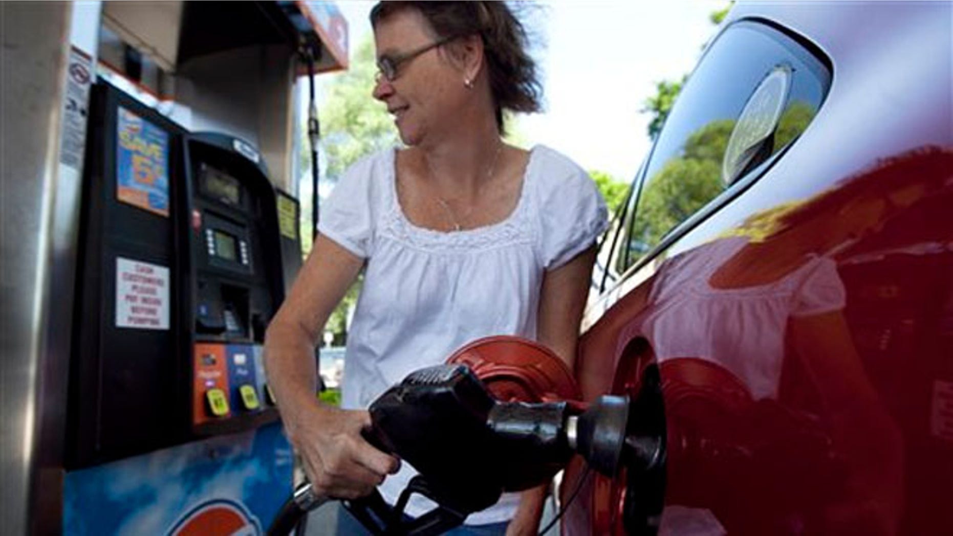 July 10, 2012: Suzanne Meredith, of Walpole, Mass., gases up her car at a Gulf station in Brookline, Mass. Gasoline is at $3.50 per gallon for the first time this summer after a sharp run-up in July.