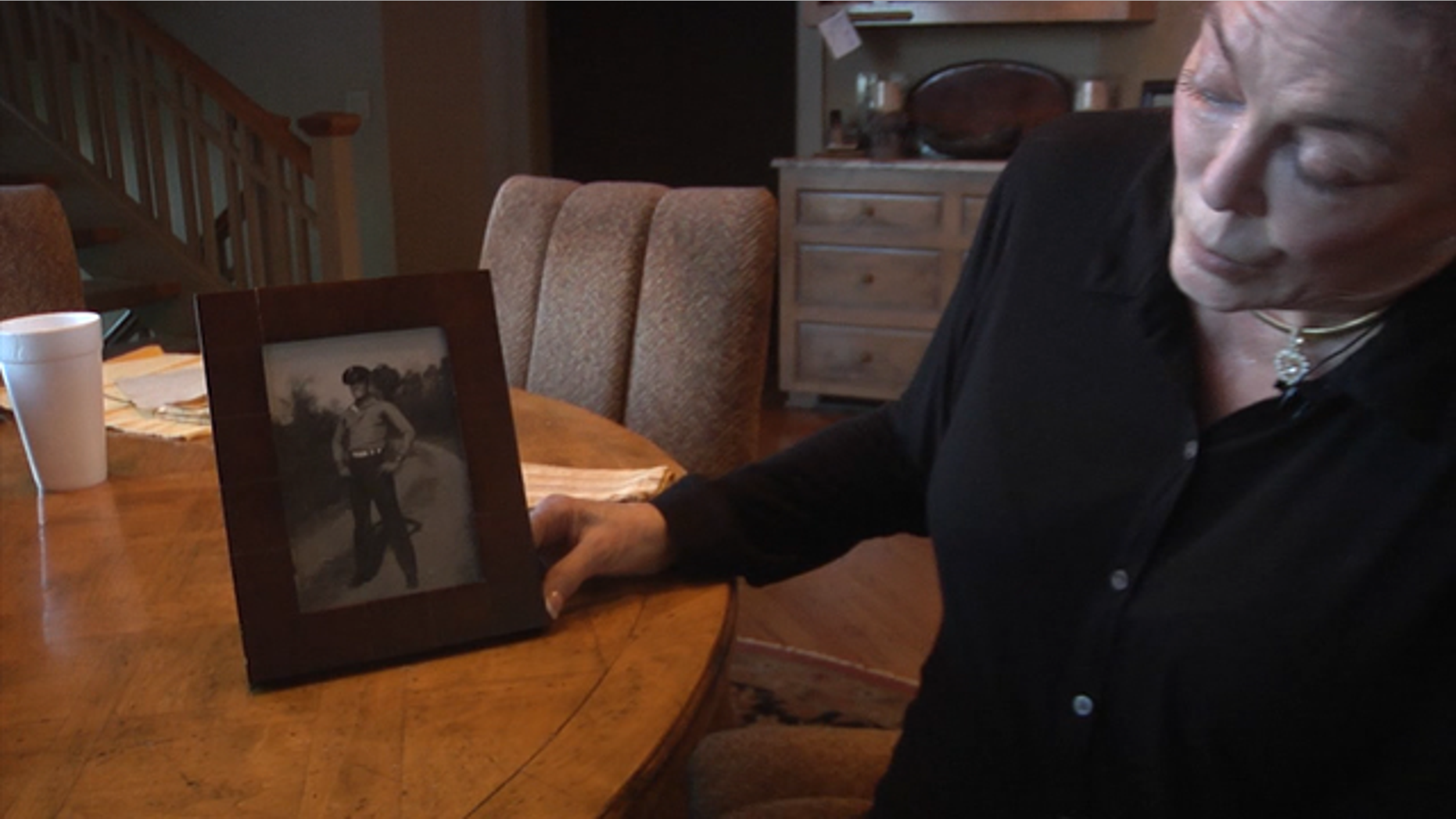 Pam Cunningham Averso displays a photo of her father in his Marine uniform.