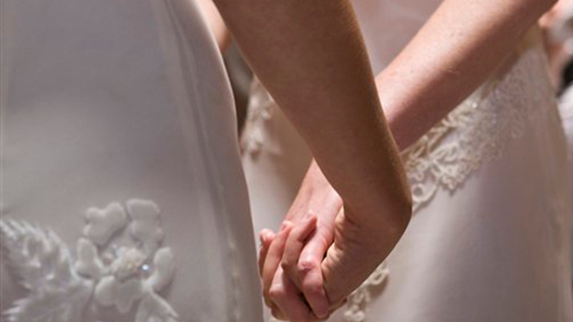 FILE - In this June 17, 2008 file photo, Amber Weiss and Sharon Papo, both of Berkeley, Calif., hold hands during their wedding ceremony at City Hall in San Francisco. What public schools will be required to teach about same-sex marriage has emerged as the central issue in the campaigns against same-sex marriage in both California and Maine.(AP Photo/Darryl Bush, FILE)
