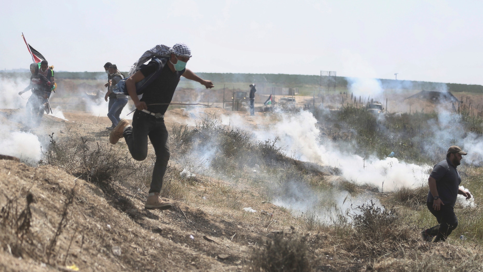 April 6, 2018: Palestinian protesters run for cover from teargas fired by Israeli troops during a protest at the Gaza Strip's border with Israel.