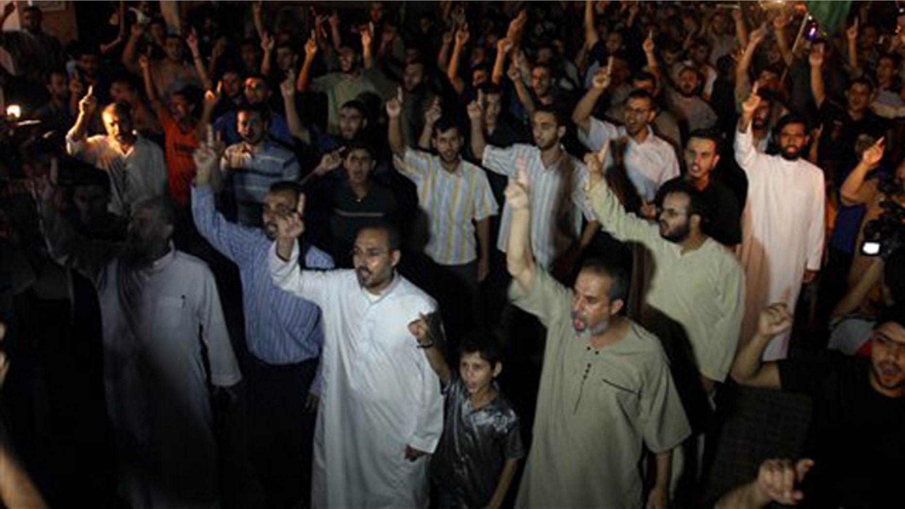 Palestinian supporters of Hamas raise their right index fingers in the air as a sign of loyalty to the group during a Gaza Strip rally to celebrate a militant attack in the southern West Bank Aug. 31. (AP Photo)