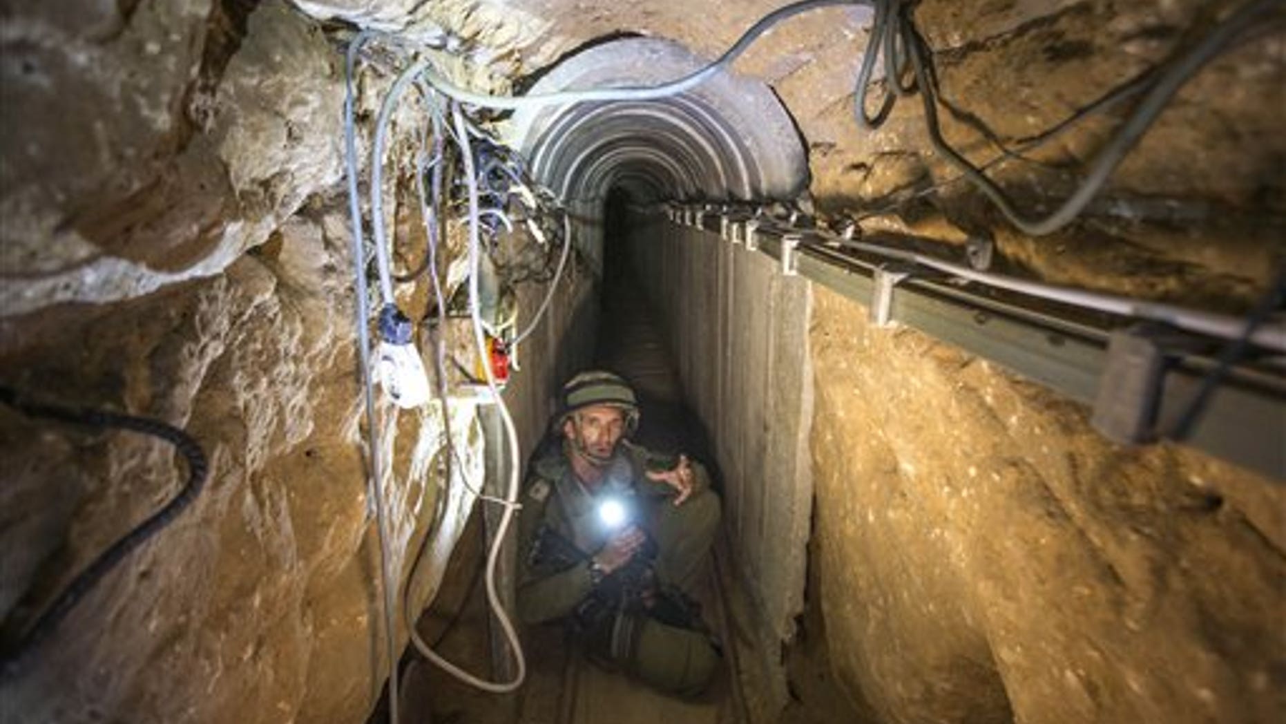 An Israeli army officer gives journalists a tour, Friday, July 25, 2014, of a tunnel allegedly used by Palestinian militants for cross-border attacks, at the Israel-Gaza Border. A network of tunnels Palestinian militants have dug from Gaza to Israel, dubbed "lower Gaza" by the Israeli military, is taking center stage in the latest war between Hamas and Israel. (AP Photo/Jack Guez, Pool)
