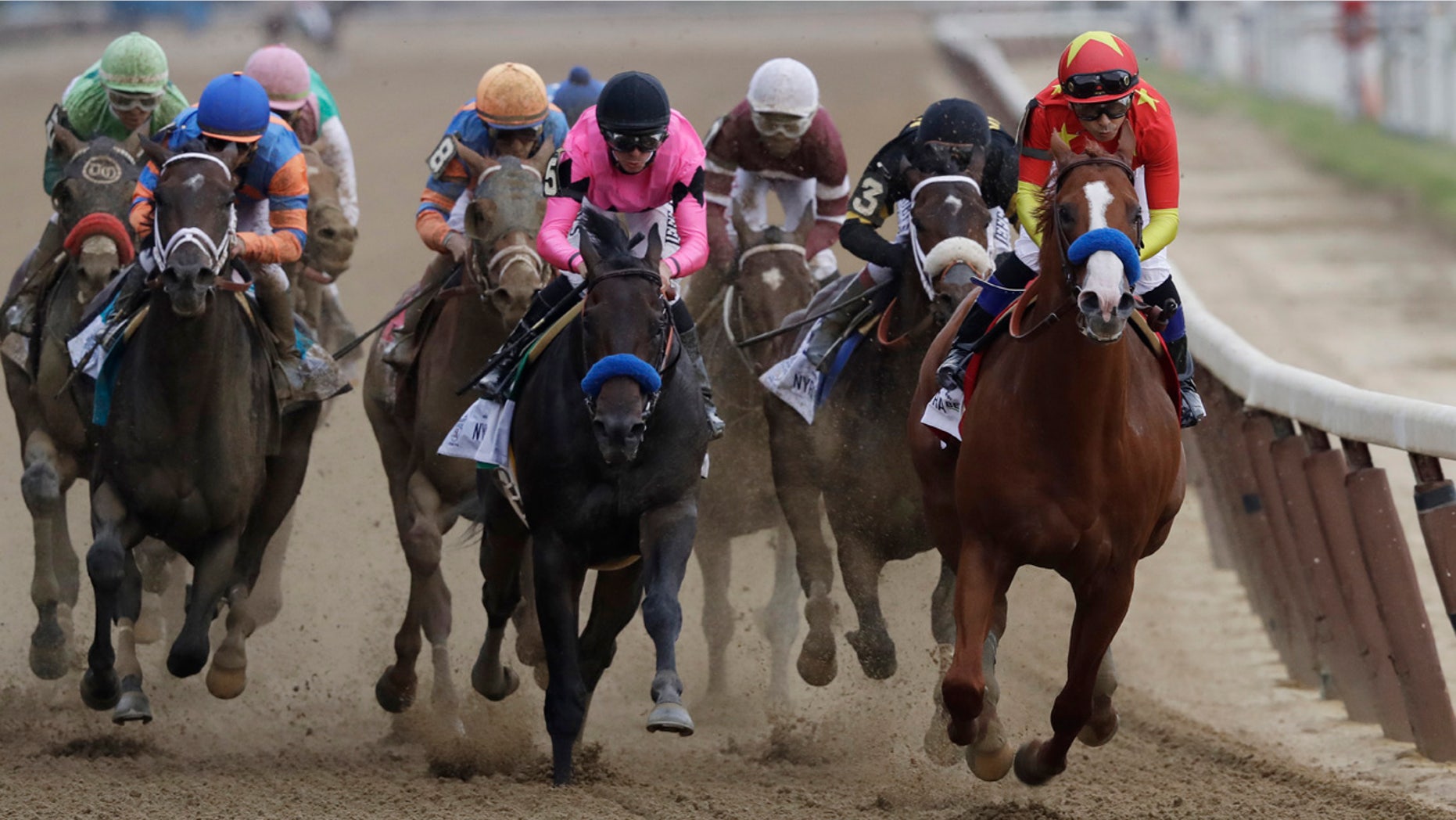 Justify, right, ridden Mike Smith leads the field at the end of the backstretch during the Belmont Stakes horse race.