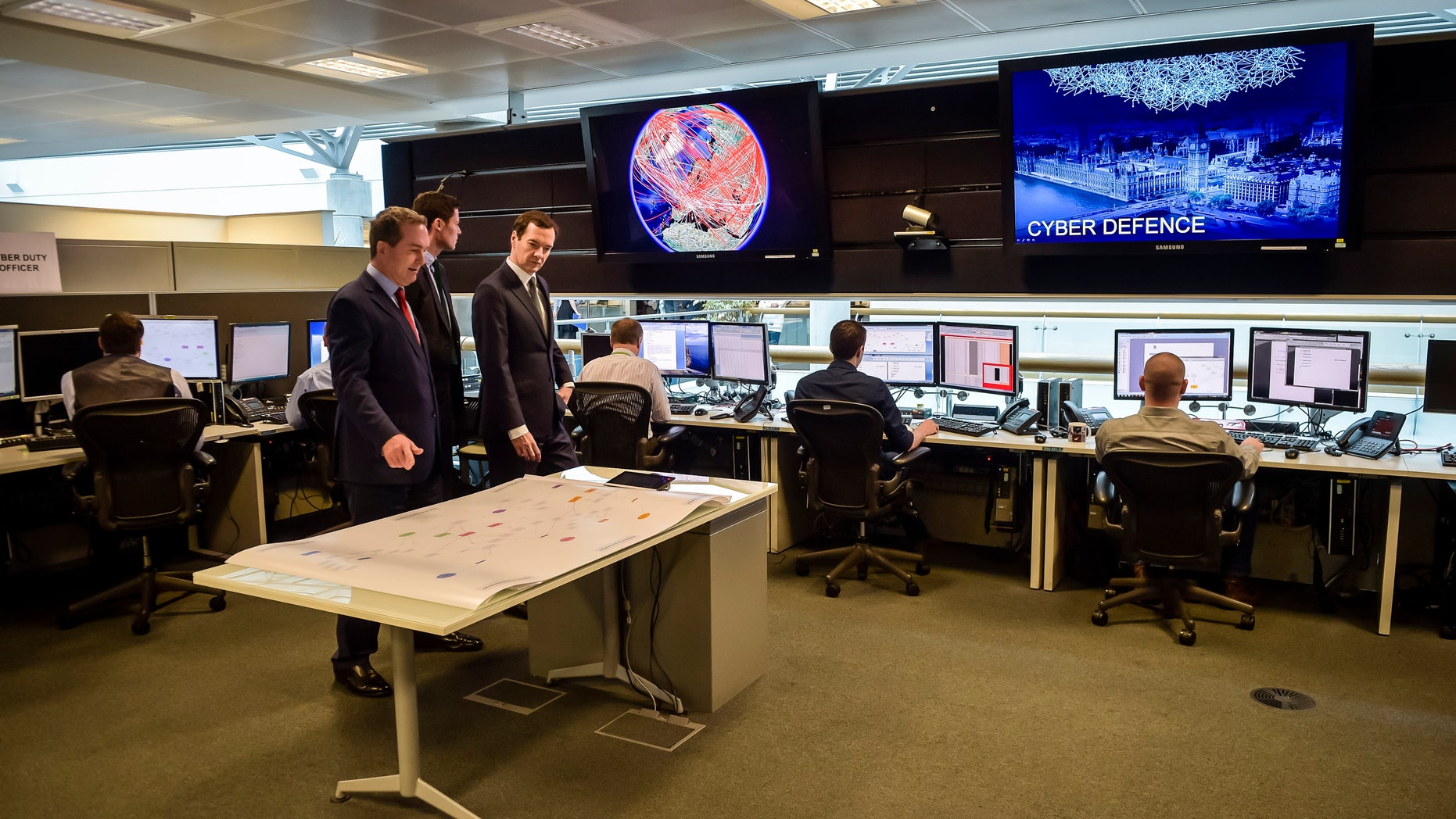 Britain's Chancellor of the Exchequer George Osborne is shown the 24 hour Operations Room inside GCHQ, by the Director of GCHQ Robert Hannigan (C) and Cheltenham MP Alex Chalk (L), in Cheltenham November 17, 2015. (REUTERS/Ben Birchall/Pool)