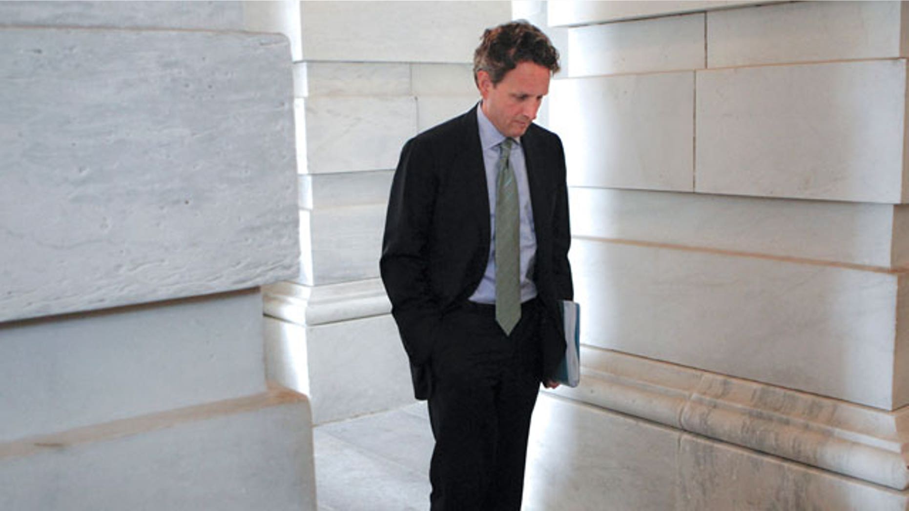 In this file photo taken June 16, 2011, Treasury Secretary Tim Geithner waits for the arrival of Vice President Joe Biden during the negotiations between Republicans and Democrats in Congress on how to solve America's debt crisis and budget problems, at the Capitol in Washington.