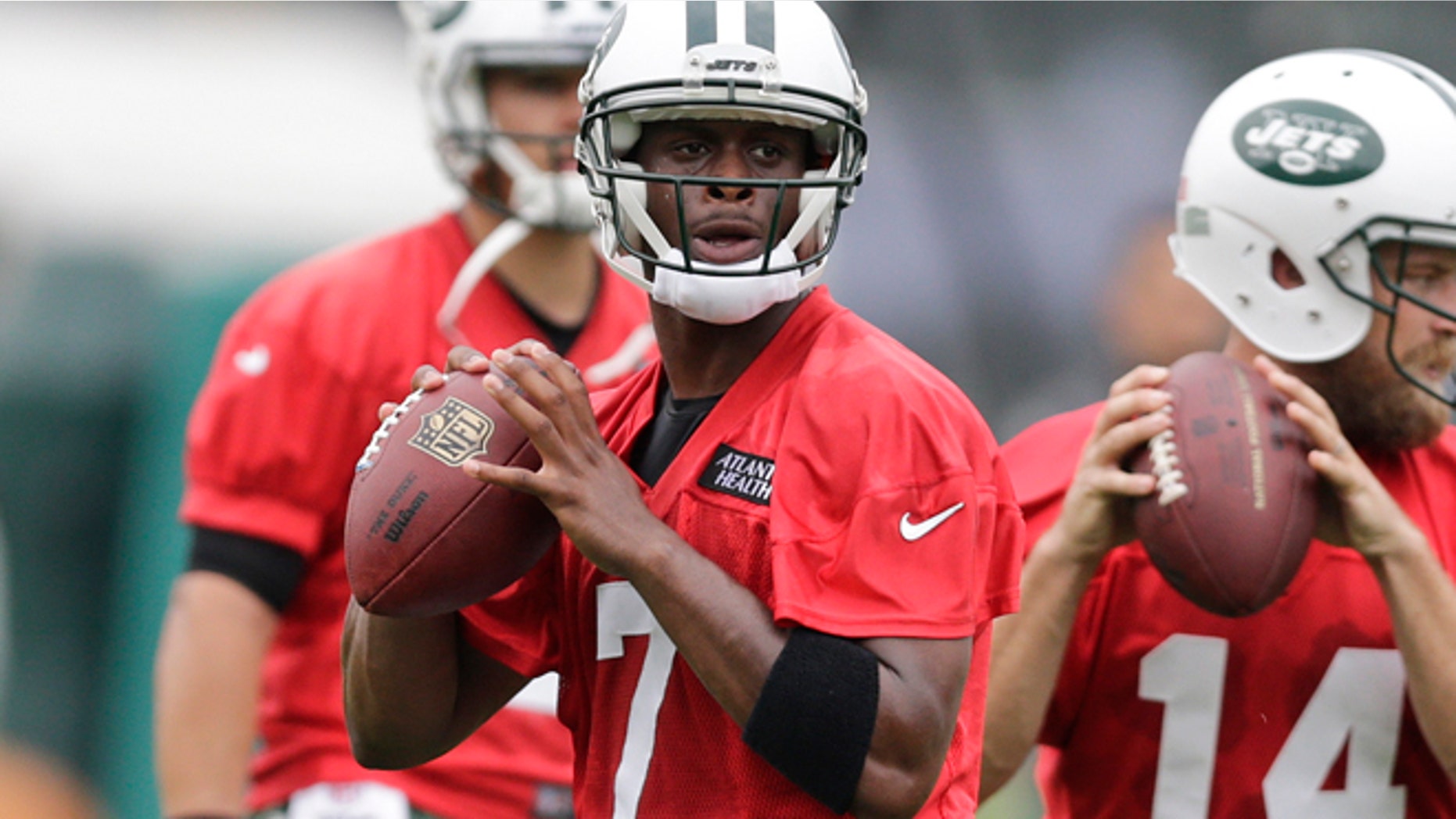 July 30, 2015: New York Jets quarterback Geno Smith, left, and quarterback Ryan Fitzpatrick, right, throw passes during drills at NFL football training camp in Florham Park, N.J.