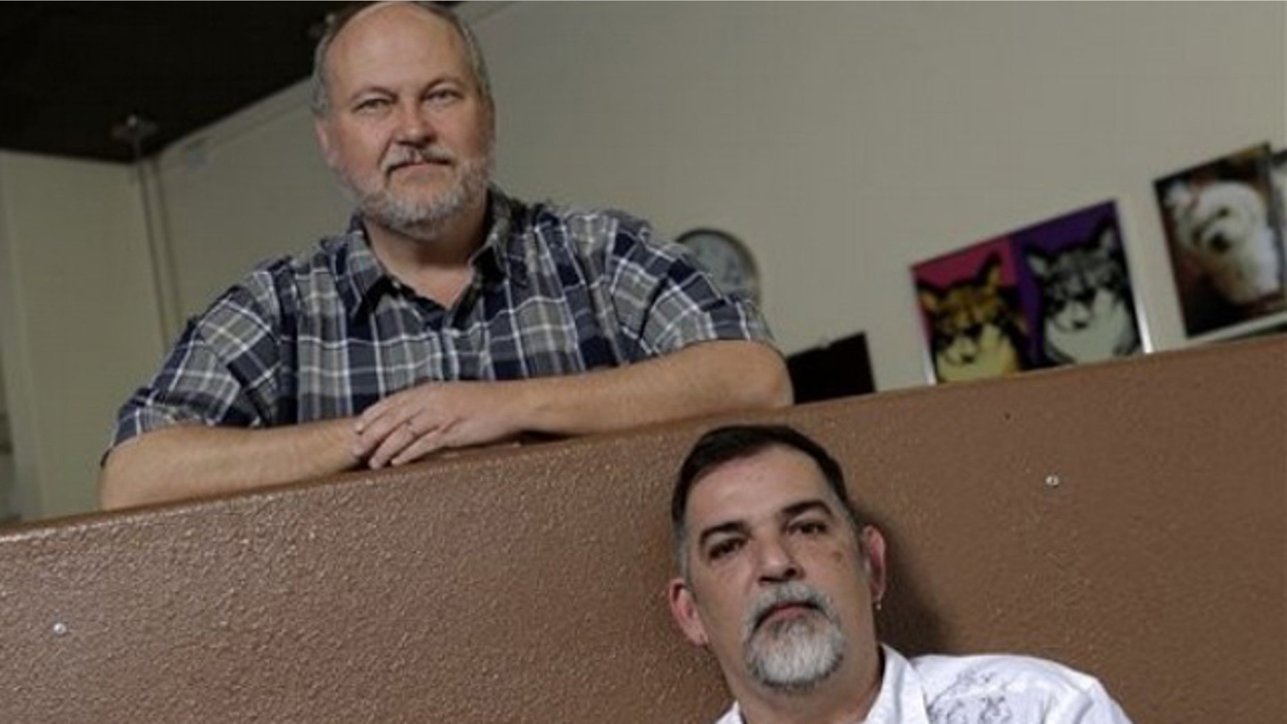May 12: Doug Gentry, bottom, and his partner, Venezuelan citizen Alex Benshimol pose for photos at their pet grooming shop in Palm Springs, Calif.