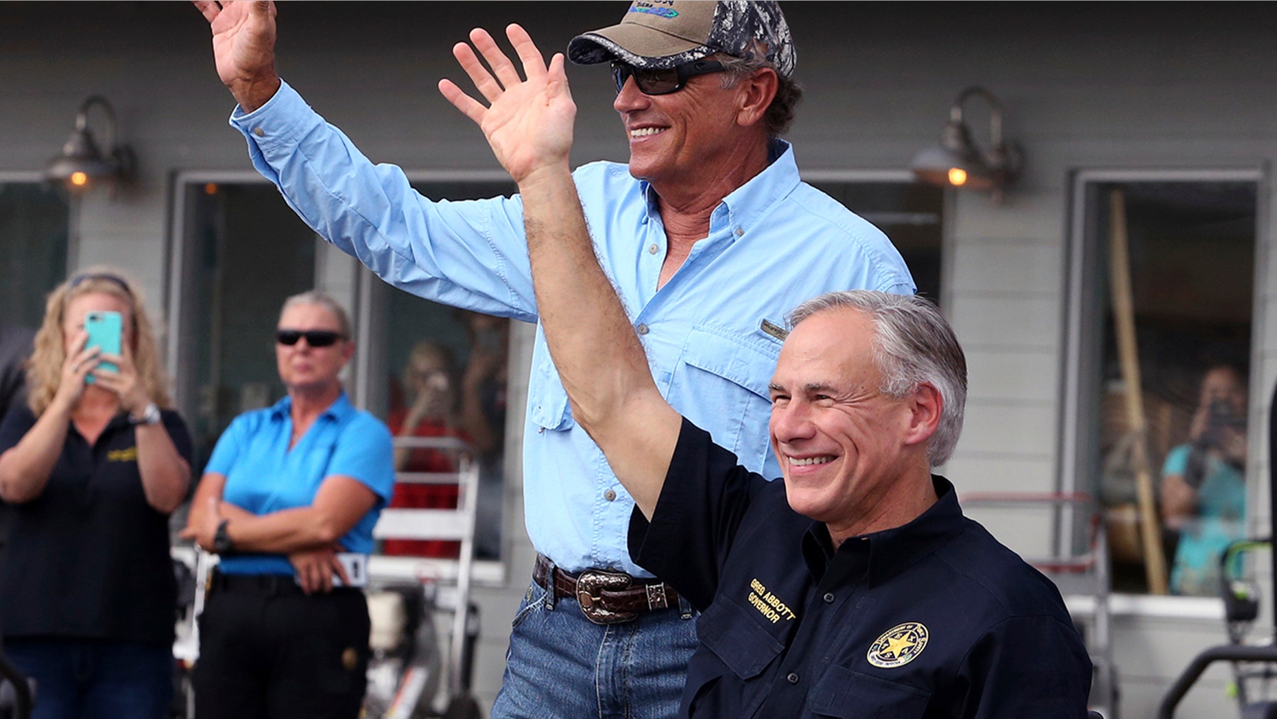 In this Sept. 21, 2017, file photo, George Strait, left, and Texas Gov. Greg Abbott wave to the crowd in Rockport, Texas, during a visit with individuals affected by Hurricane Harvey. Strait leads a new tourism campaign for Hurricane Harvey-damaged Rockport and Fulton nearly 10 months after the storm devastated the area he sometimes calls home. Strait is part of the "Find Yourself in Rockport-Fulton" radio and TV campaign to encourage tourists to return to the area hard-hit when Harvey made landfall in August.