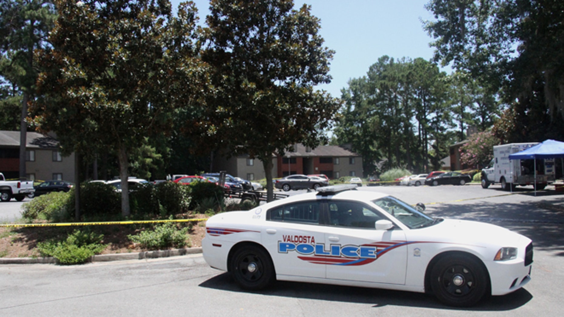 A police vehicle parks near the scene of an officer involved shooting, Friday, July 8, 2016, in Valdosta, Ga. A man who called 911 to report a car break-in Friday ambushed a south Georgia police officer dispatched to the scene, sparking a shootout in which both the officer and suspect were wounded, authorities said. Both are expected to survive.(Gabe Burns/The Daily Times via AP) MANDATORY CREDIT