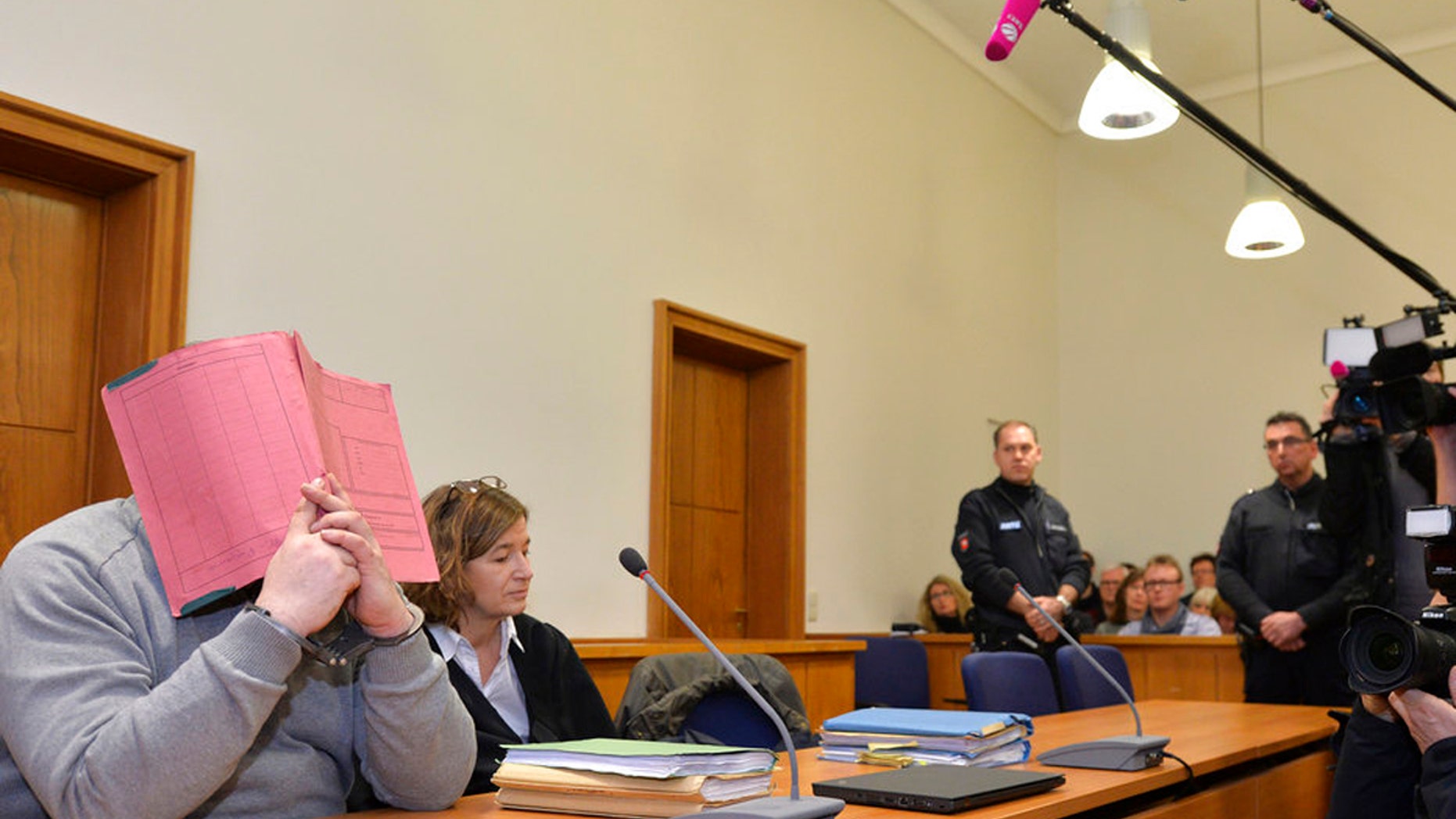 Former nurse Niels Hoegel, accused in the murder of 97 patients, covers his face in this file photograph.
