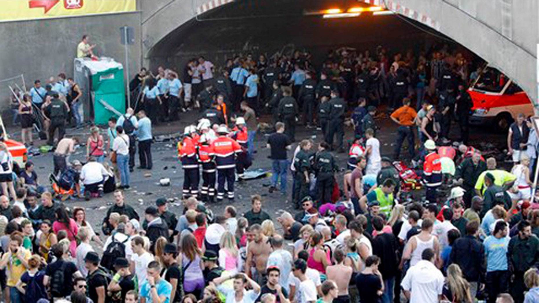 Collapsed people get first aid after a panic on this year's techno-music festival "Loveparade 2010" in Duisburg, Germany, on Saturday, July 24, 2010. German police say that 10 people were killed and 15 others injured when mass panic broke out in a tunnel at the Love Parade. (AP Photo/dapd/Hermann J. Knippertz)