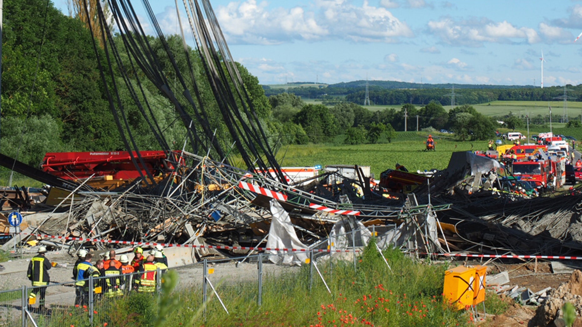 June 15, 2016: Firefighters stand near a collapsed scaffolding at a highway bridge near Werneck northern Bavaria, Germany.