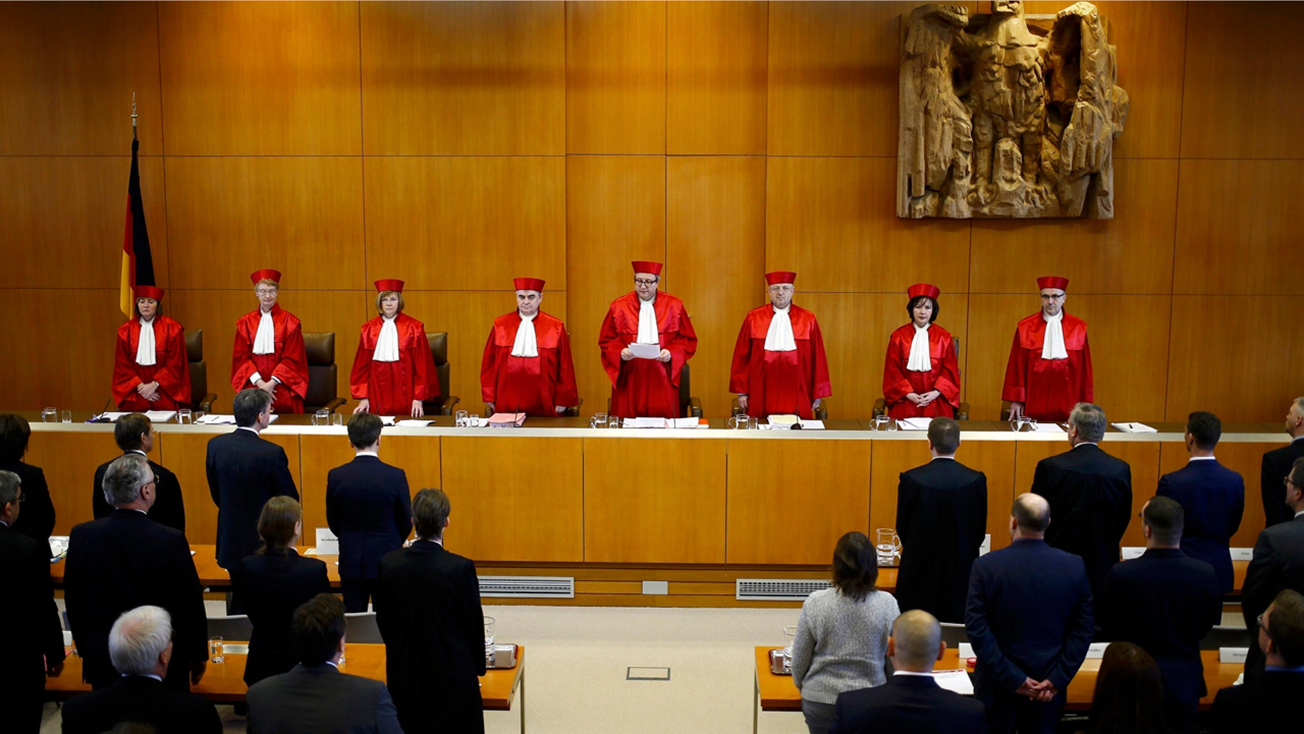 The judges of the German Constitutional Court, from left, Christine Langenfeld, Doris Koenig, Monika Hermanns, Peter Mueller, presiding judge Andreas Vosskuhle, Peter M. Huber, Sibylle Kessal-Wulf and Ulrich Maidowski announce that they rejected a bid of banning the far-right NPD party in Karlsruhe, southern Germany, Tuesday, Jan. 17, 2017. (Kai Pfaffenbach/Pool Photo via AP)