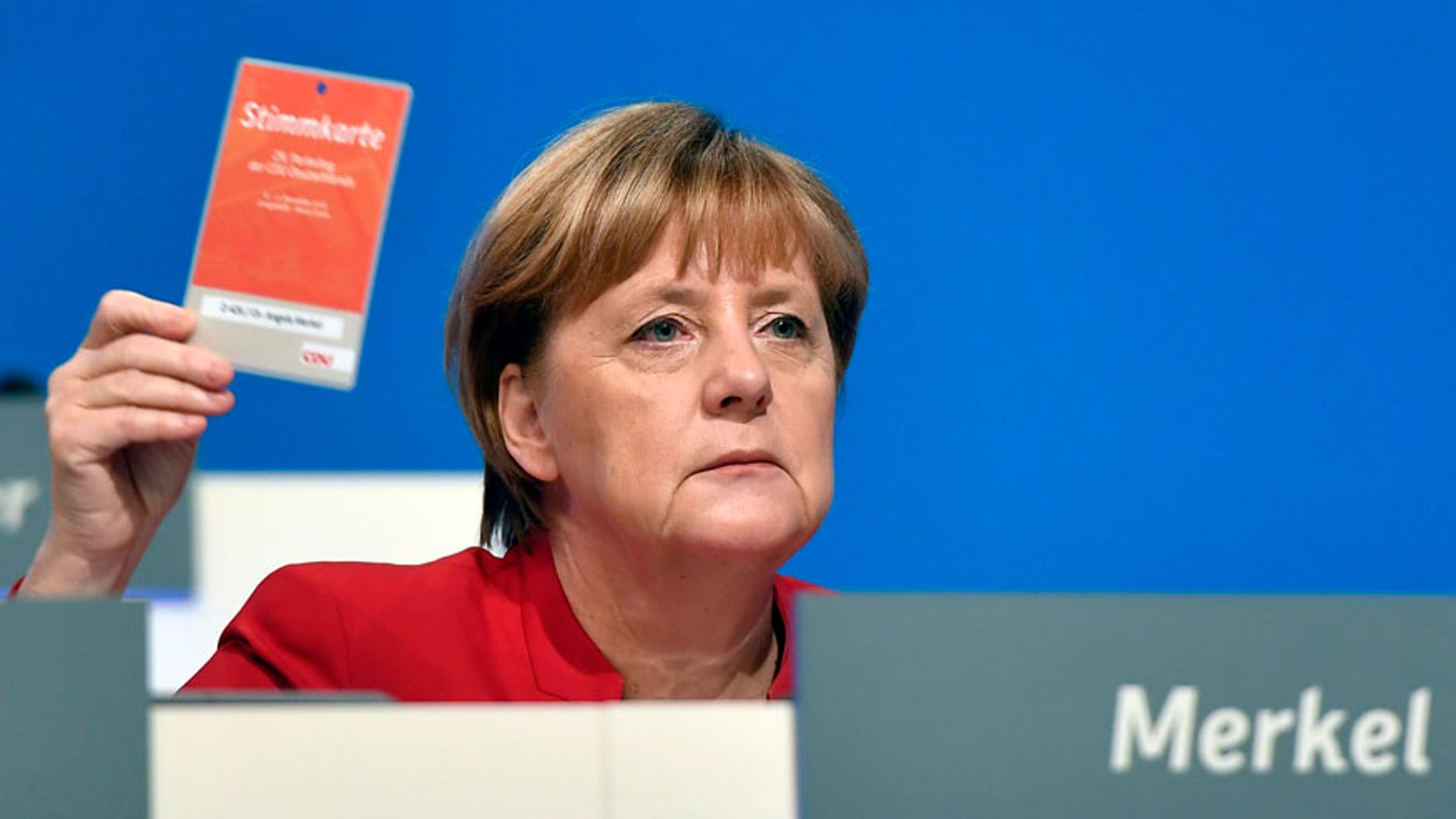 German Chancellor and Chairwomen of the CDU, Angela Merkel, holds an voting ticket during a party conference of the Christian Democratic Union (CDU) in Essen, Germany, Tuesday, Dec. 6, 2016. Chancellor Angela Merkel has won a new two-year term as leader of Germany's main conservative party after she won 89.5 percent of delegates' votes at a party congress. (AP Photo/Martin Meissner)