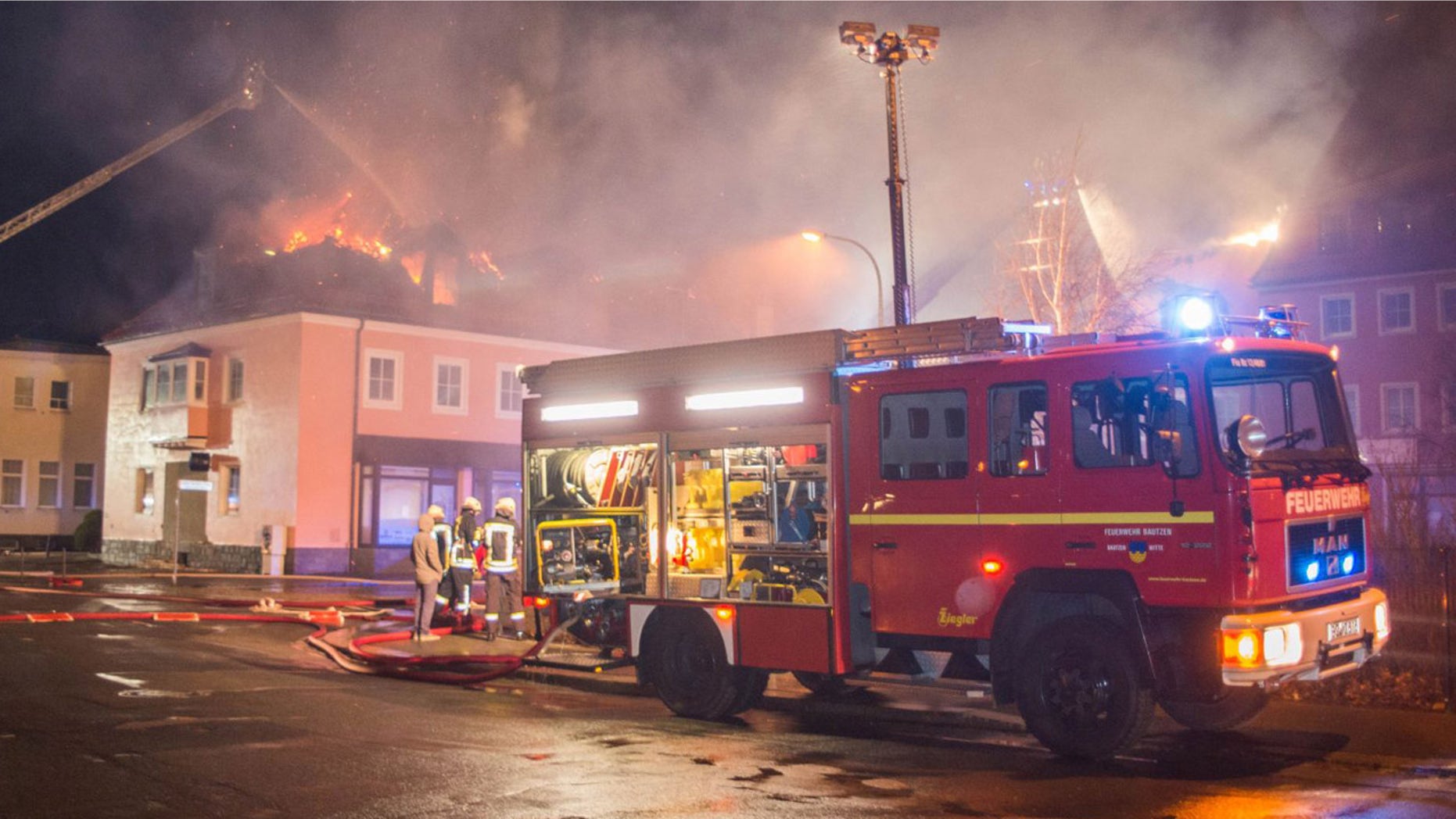 Feb. 21, 2016: A fire engine stands in front of a burning building in Bautzen, eastern Germany. The fire damaged a former hotel that was being converted into a refugee home and two people were detained after hindering firefighters work, police said (Rico Loeb/dpa via AP)