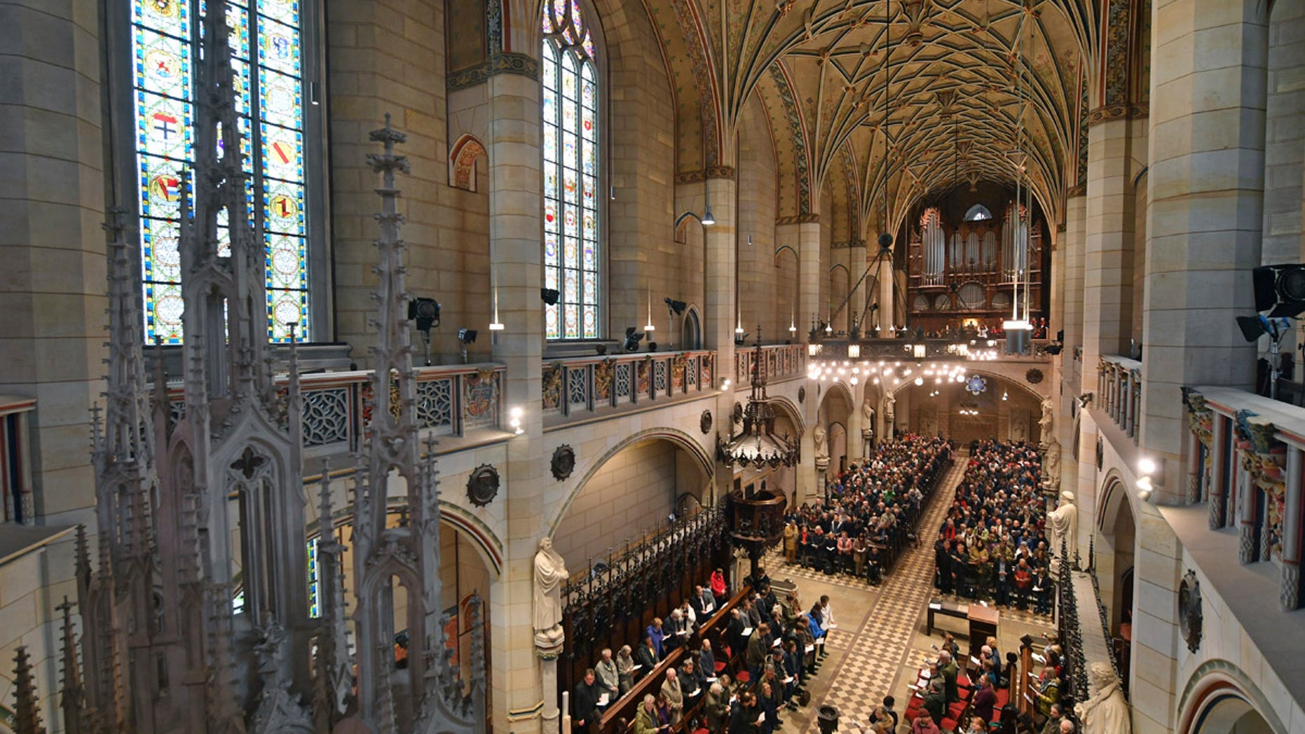 Visitors of the service sit in the All Saints' Church or Castle Church in Wittenberg, Germany, Tuesday Oct. 31, 2017. German leaders will mark the 500th anniversary of the day Martin Luther is said to have nailed his theses challenging the Catholic Church's practice of selling indulgences to a church door, a starting point of the Reformation. (Hendrik Schmidt/dpa via AP)