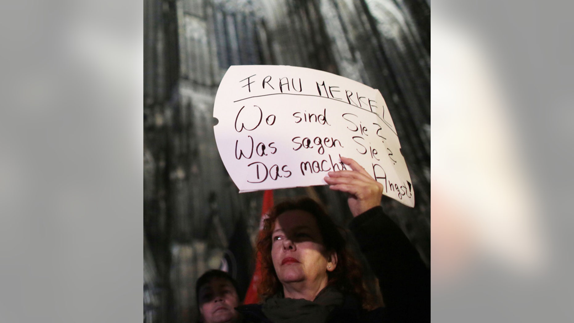A woman protests against sexism outside the cathedral in Cologne, Germany, Tuesday Jan. 5, 2016. Poster reads " Mrs. Merkel. Where are you? What do you say? It's scary." (Associated Press)