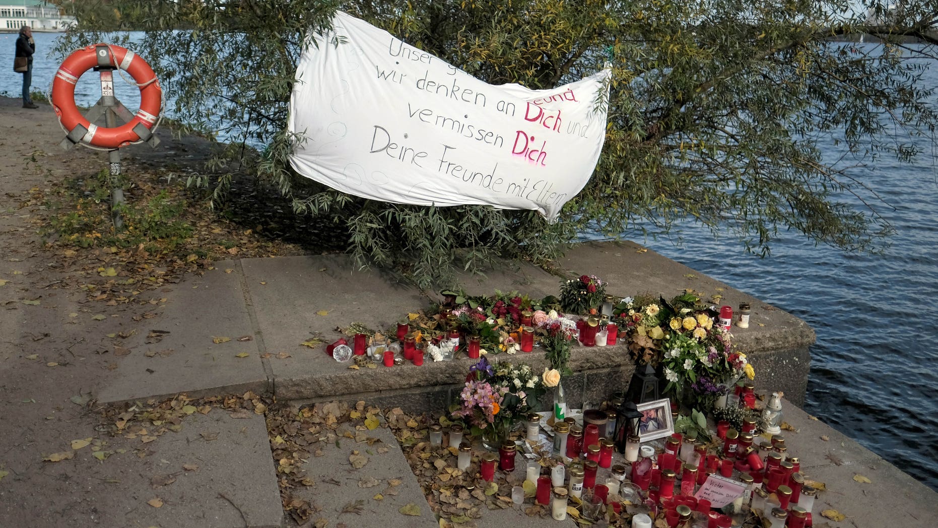 A banner, candles and flowers mark the spot where two teens were attacked in Hamburg.