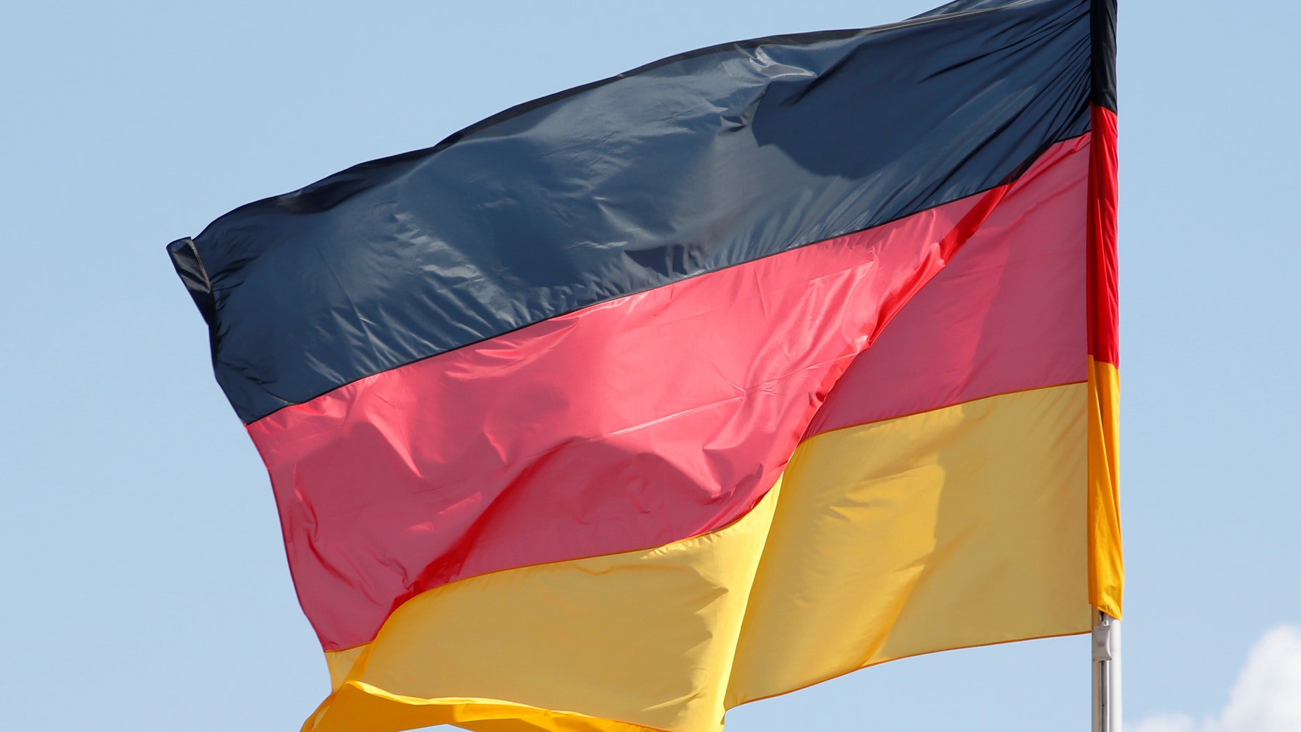 File photo - The German national flag is seen on a sunny day surrounded by some clouds at the Chancellery in Berlin, Germany, April 29, 2016. (REUTERS/Fabrizio Bensch)