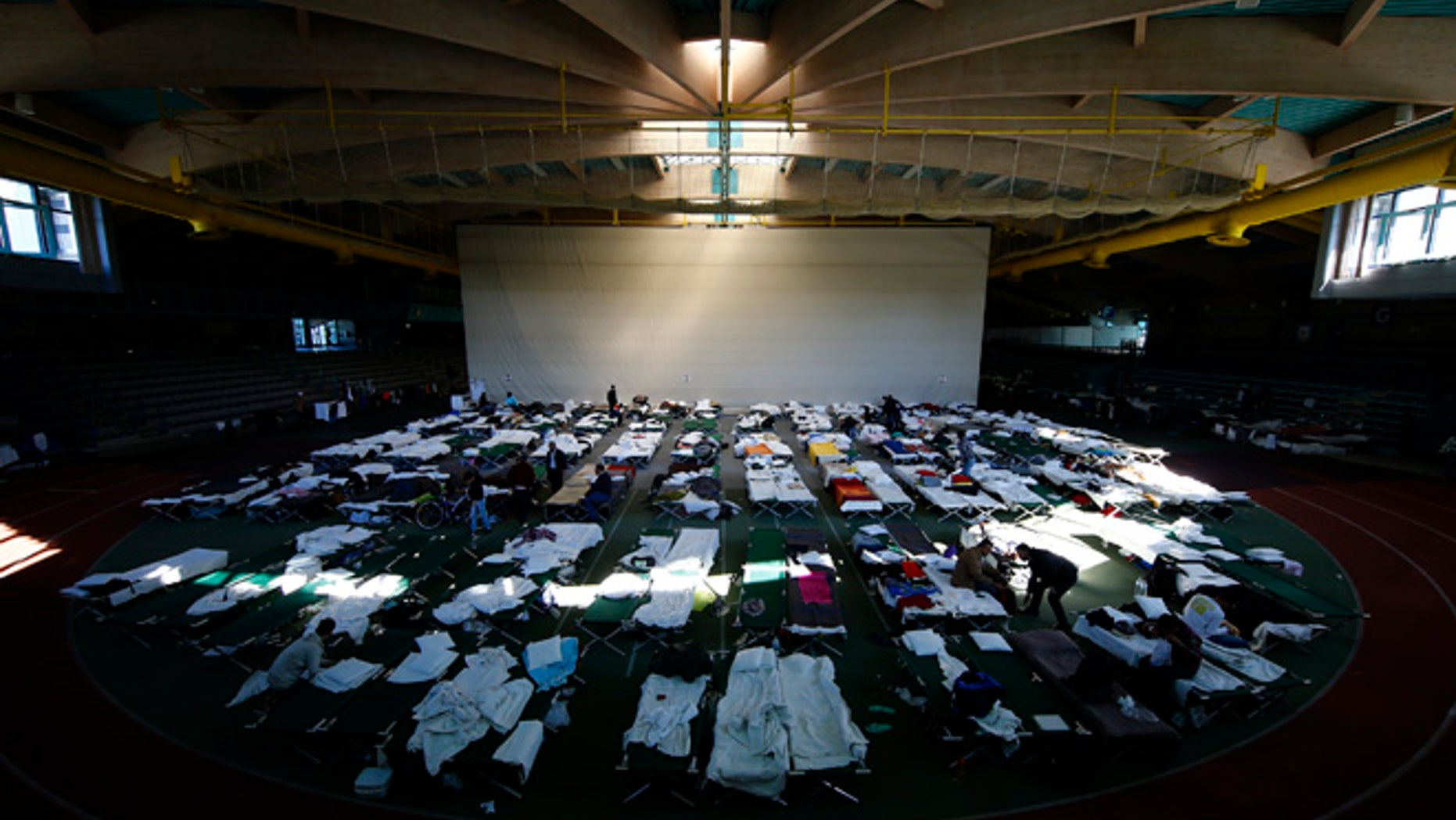 October 1, 2015: Migrants rest at a temporary shelter in a sports hall in Hanau, Germany.