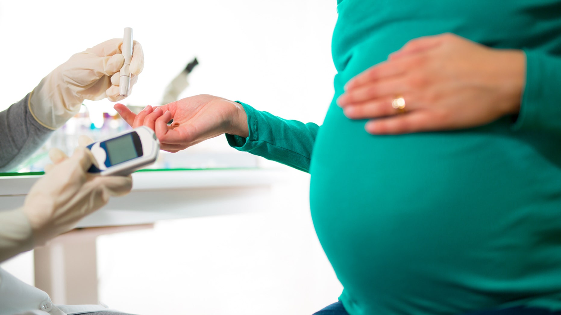 A pregnant woman gets her blood sugar/glucose checked.