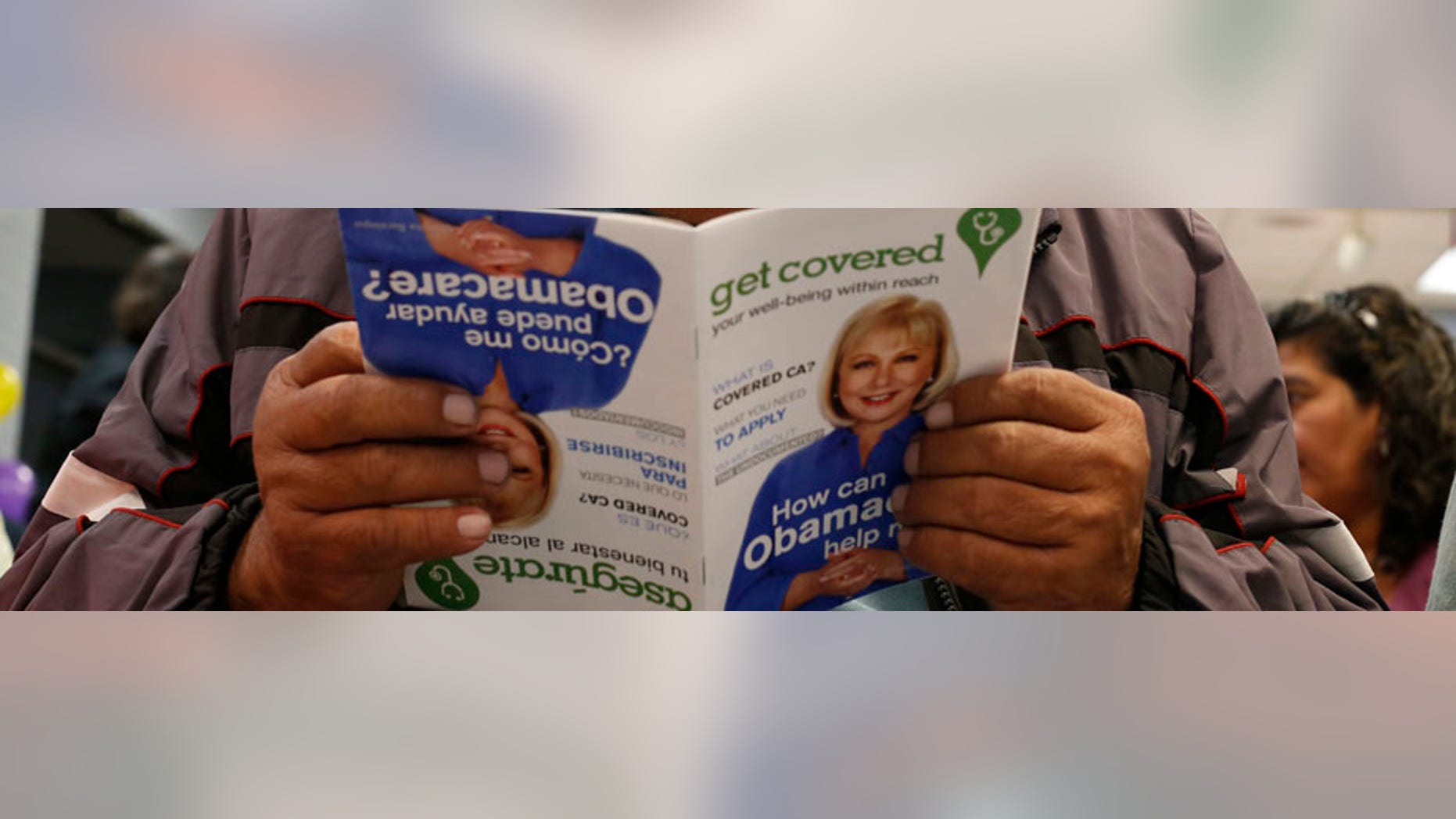 Jesus Dominguez, 63, who does not have health insurance, reads a pamphlet at a health insurance enrollment event in Cudahy, California.