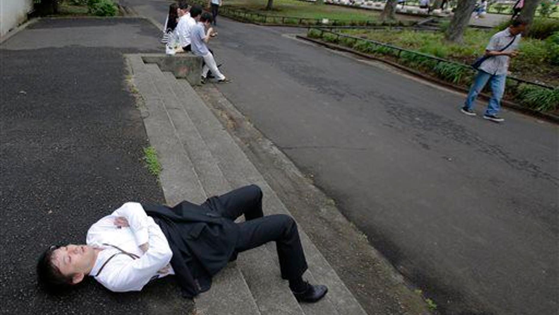 A man takes a nap as he takes advantage of a break of the rainy season at Hibiya Park in Tokyo, Tuesday, June 10, 2014. Is he "violating spatial norms"?