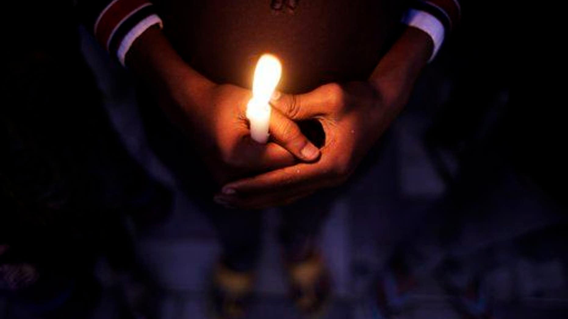 An Indian child holds a candle during a candlelight vigil in New Delhi, India, in this 2014 file photo.