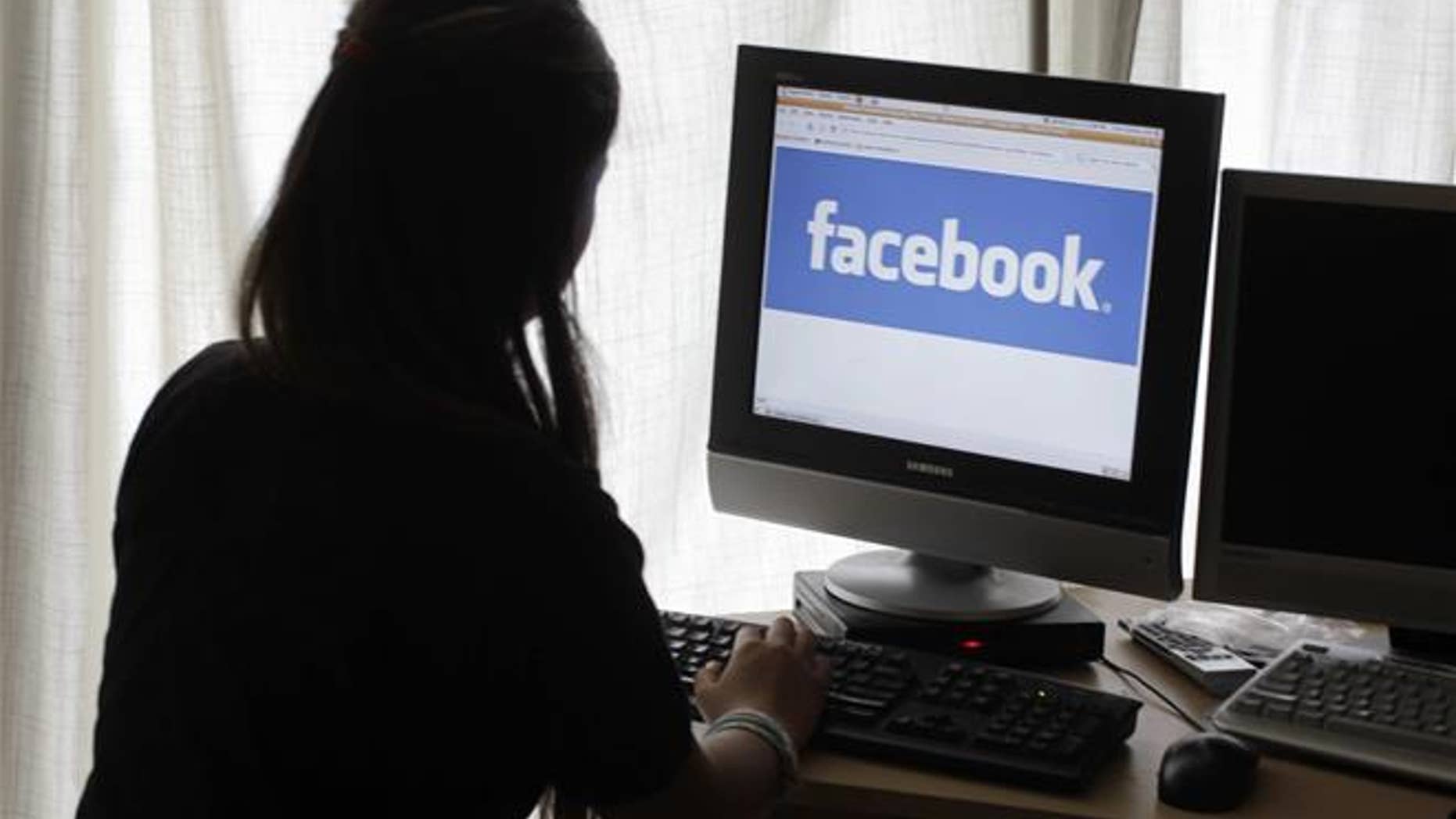 In this Monday, June 4, 2012, file photo, a girl looks at Facebook on her computer in Palo Alto, Calif.