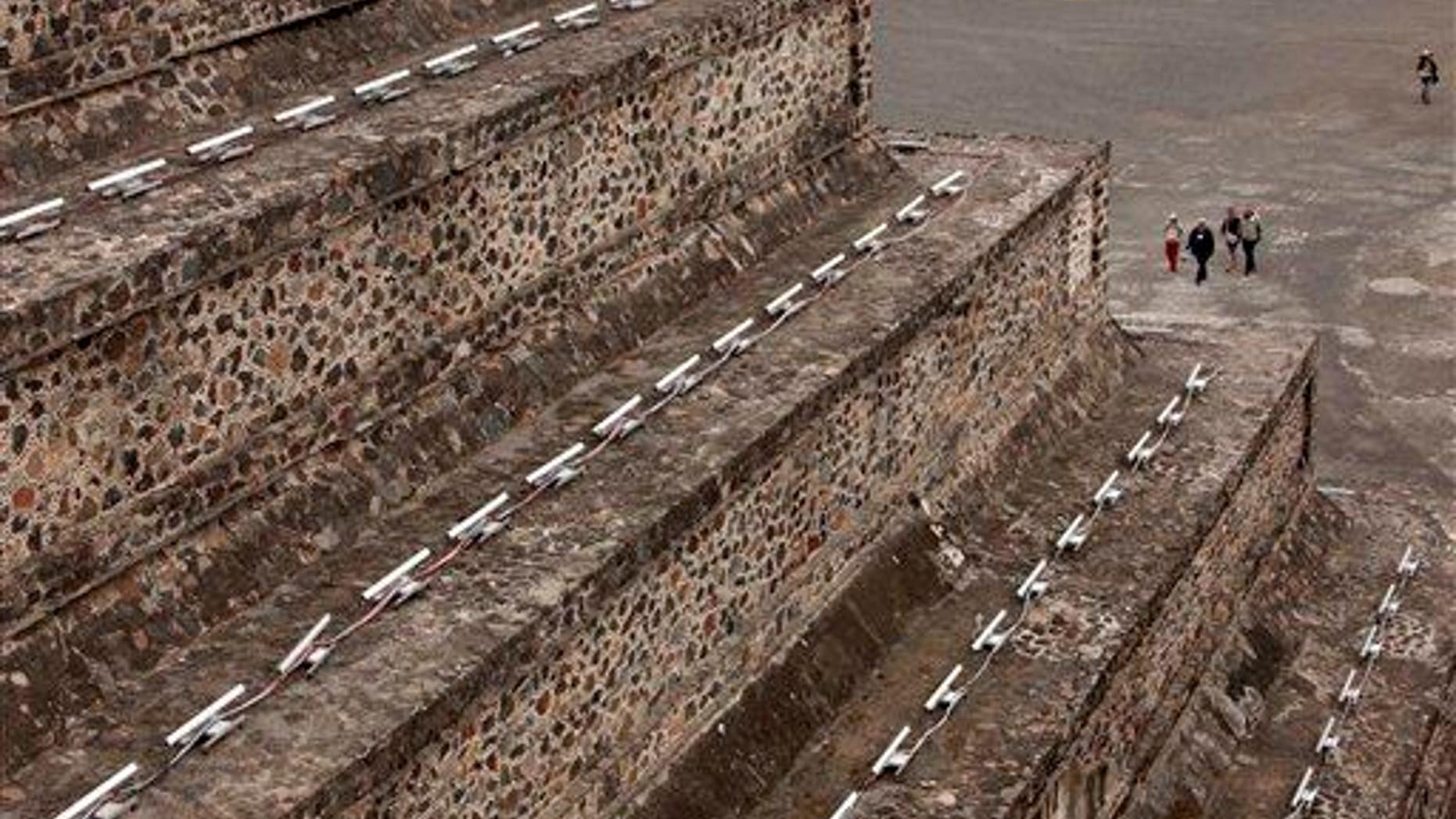 Tourists walk toward the Pyramid of the Moon in Teotihuacan, Mexico.