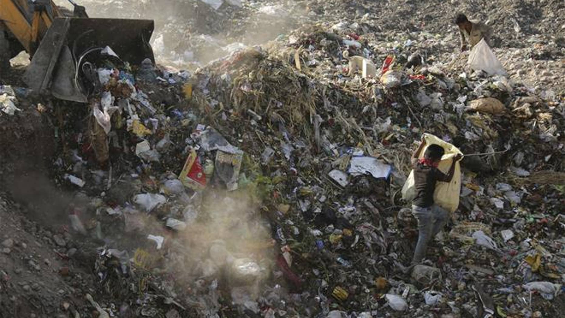 In this April 21, 2017, photo, an excavator dumps garbage at a landfill on the outskirts of Jammu, India. Much of the plastic we produce ends up in landfills.