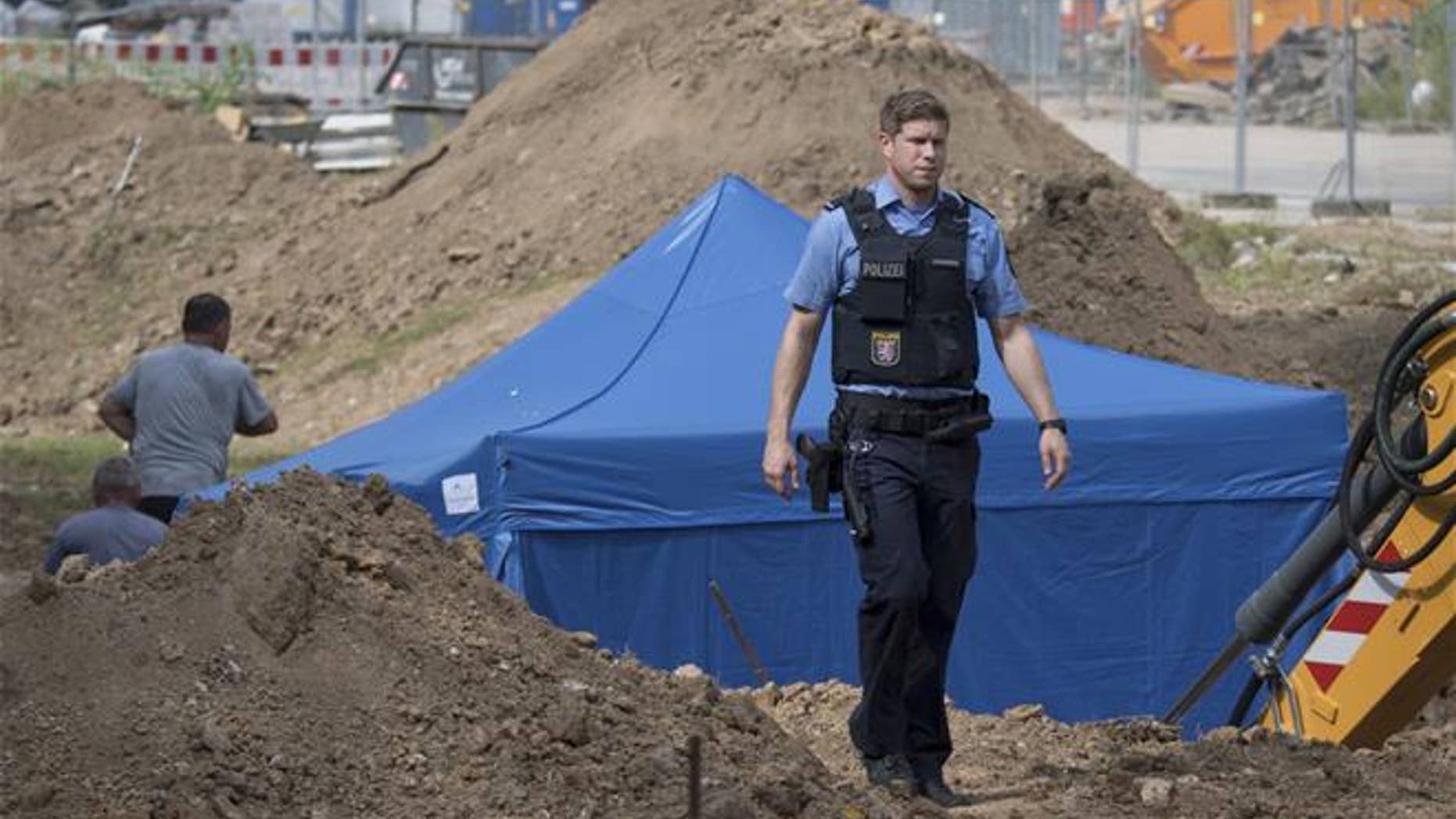 In this photo taken Wednesday, Aug. 30, 2017 in Frankfurt, Germany, a police officer passes a blue tent that was set up over a bomb of a type dropped by British bombers during World War II.