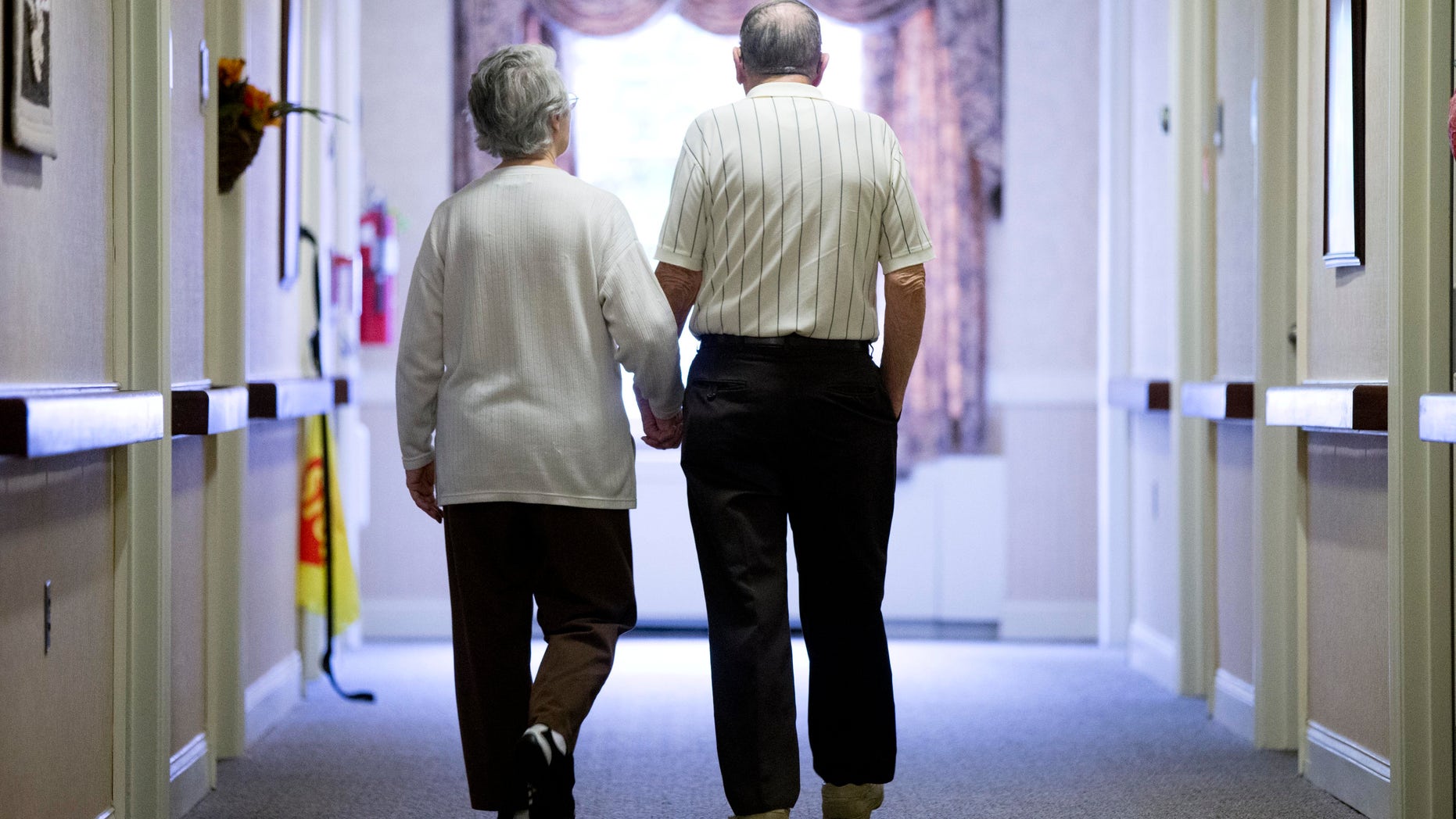 In this Nov. 6, 2015 file photo, an elderly couple walks down a hall in Easton, Pa. It's not too late to get moving: Simple physical activity, mostly walking, helped high-risk seniors stay mobile after disability-inducing ailments even if, at 70 and beyond, they'd long been couch potatoes.