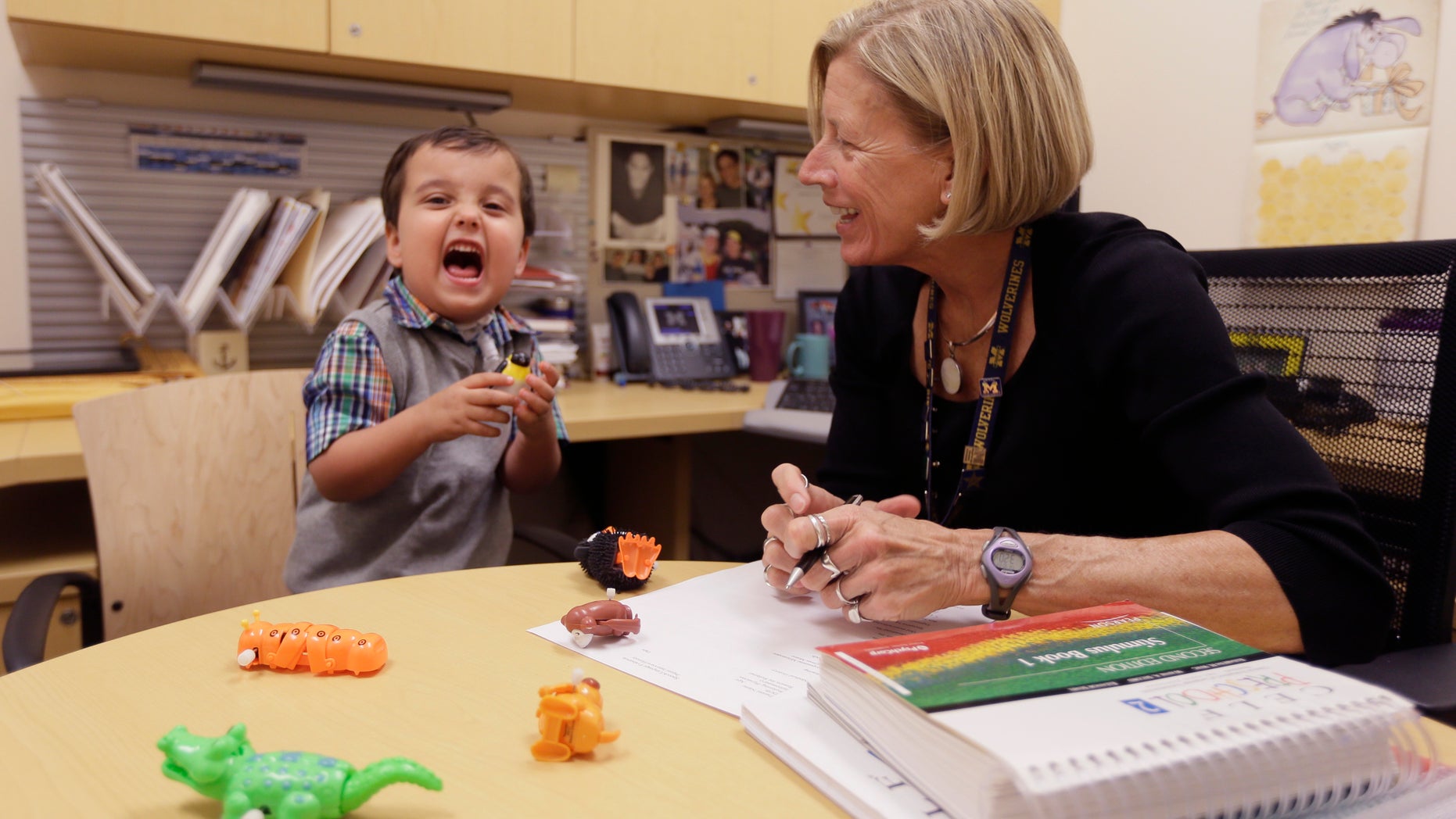 In a photo from Thursday, Oct. 22, 2015, in Ann Arbor, Mich., Grant Hasse yells out a word next to Lynn Driver, a speech-language pathologist at the University of Michigan's C.S. Mott Children's Hospital. (AP Photo/Carlos Osorio)
