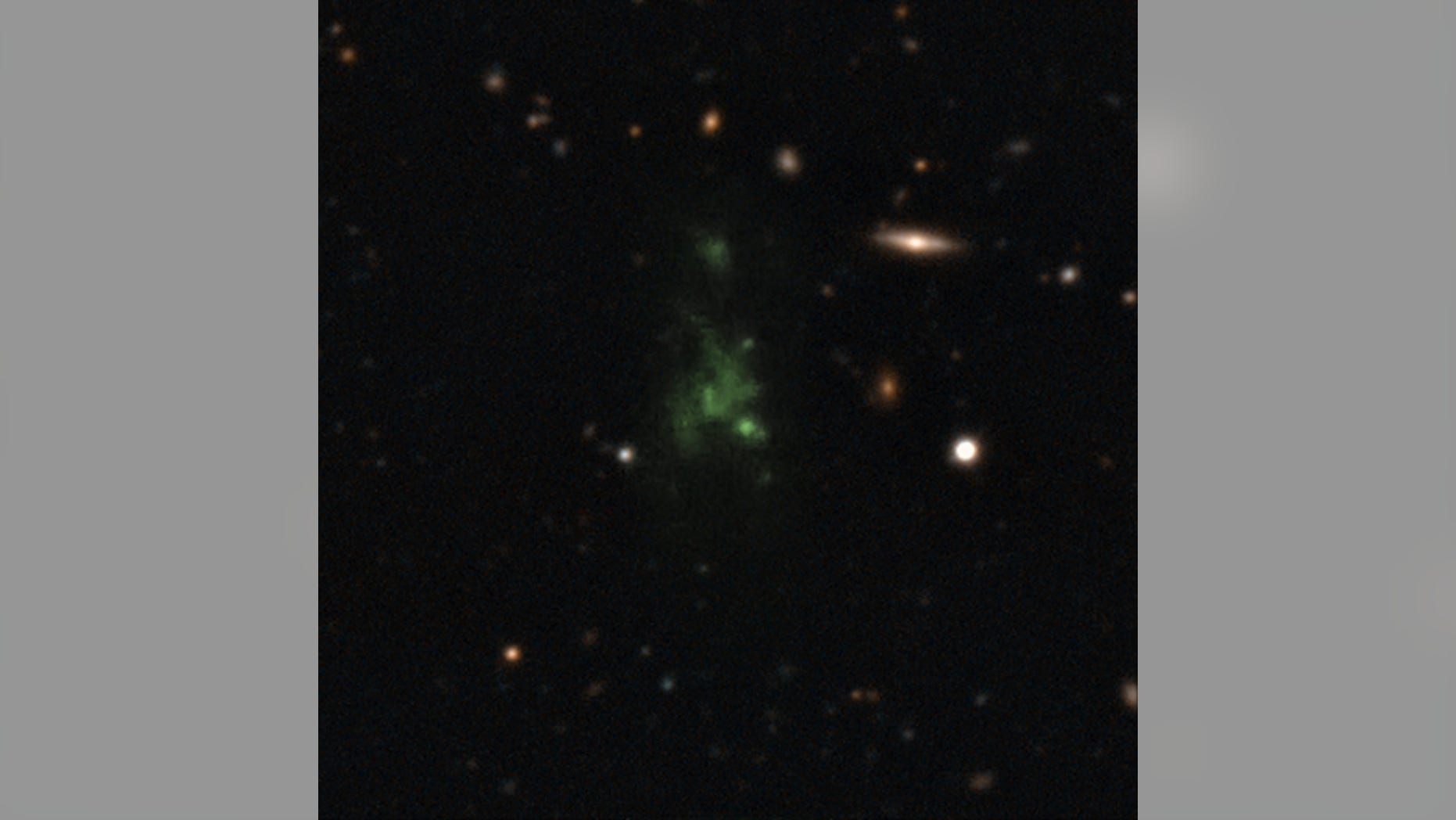 A giant green "space blob" - called the Lyman-alpha blob LAB-1 - is seen in this composite of two different images taken by the Very Large Telescope in Chile. The LAB-1 space blob is 300,000 light-years across,