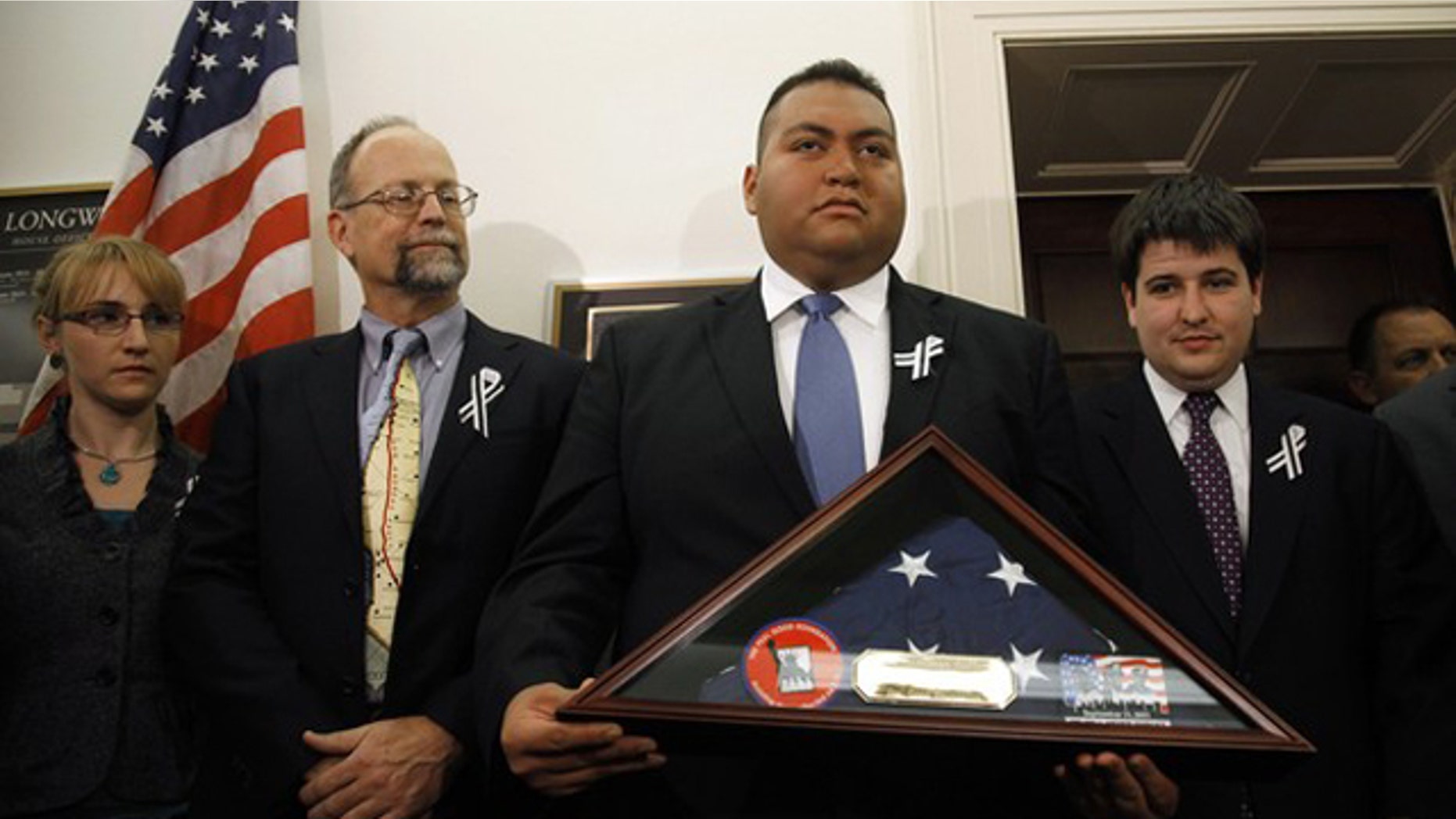 January 25: Daniel Hernandez, the intern credited with saving the life of U.S. Congresswoman Gabrielle Giffords after she was shot in Arizona, holds a U.S. flag presented to him by first responders from the September 11, 2001 attack on New York's World Trade Center