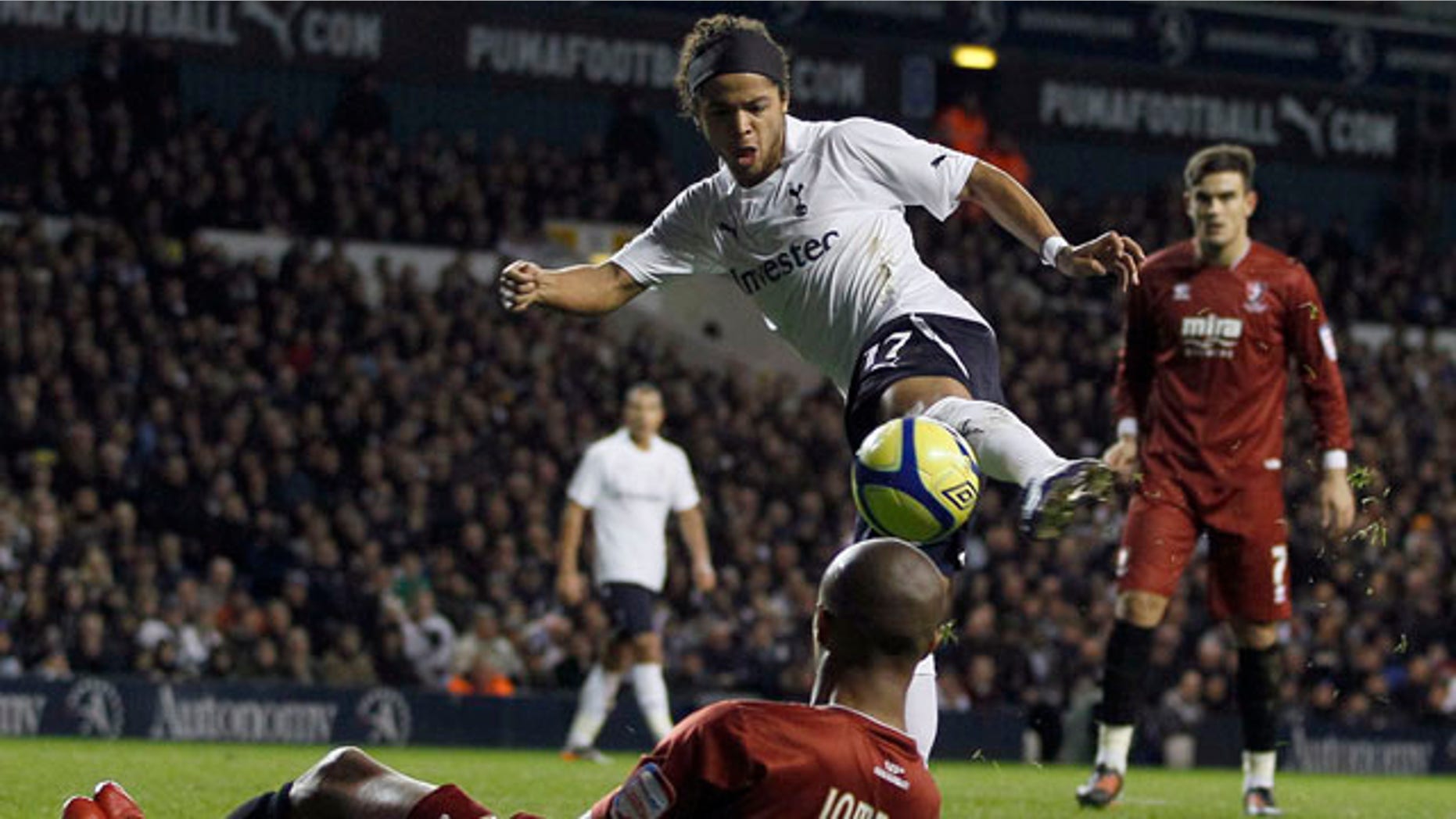 Tottenham Hotspur's Giovani Dos Santos, top, vies for the ball with Cheltenham Town's Sido Jombati during the English FA Cup third round soccer match at White Hart Lane Stadium in London, Saturday Jan. 7, 2012. (AP Photo/Kirsty Wigglesworth)