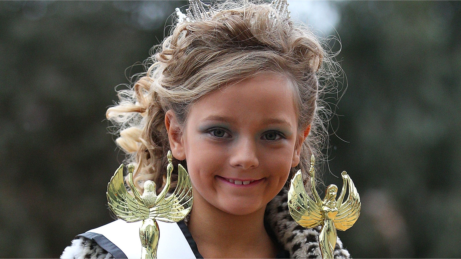 MELBOURNE, AUSTRALIA - JULY 30: A girl holds her two trophies that she won after competing in a child beauty pageant at Northcote Town Hall on July 30, 2011 in Melbourne, Australia. The controversial child beauty competition, kicked off today in Melbourne despite complaints and demonstrations by pageant opponents. Organised by the US-based pageant company that produces reality TV show "Toddlers and Tiaras", Australian contestants will have the opportunity to pose with the reality show star, six year-old Eden Wood. (Photo by Scott Barbour/Getty Images)