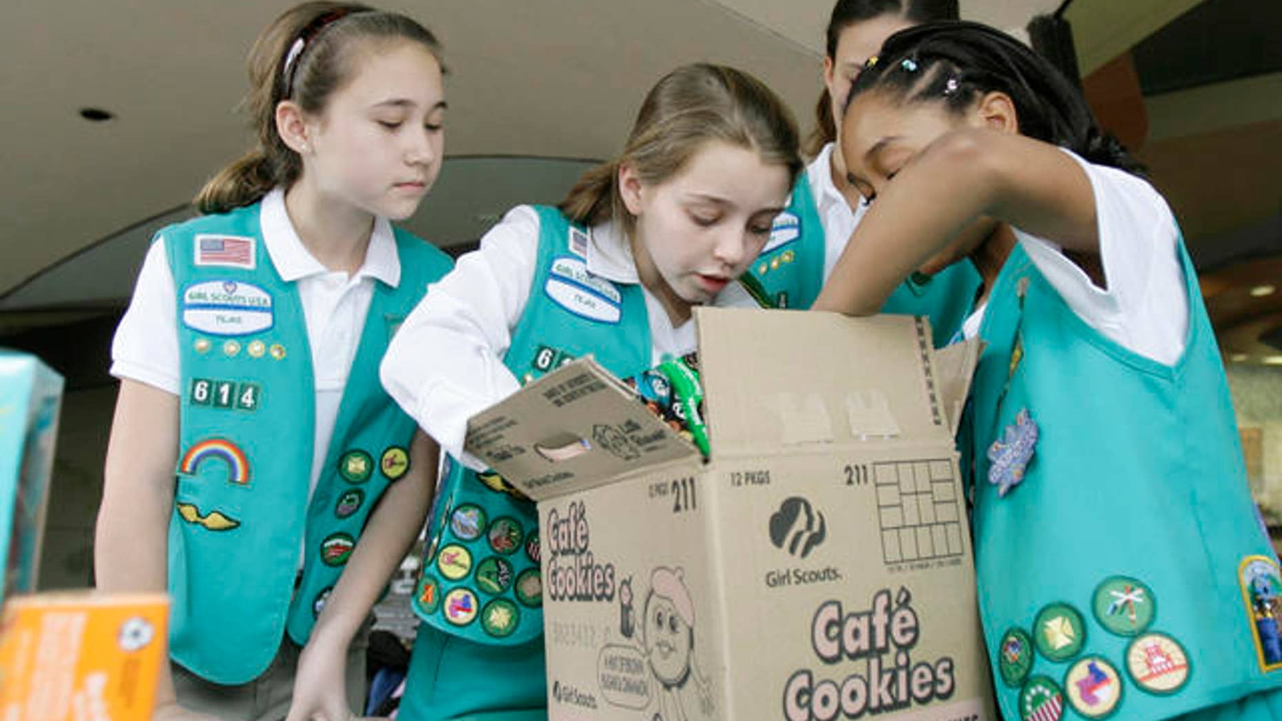 File Photo: Girl Scouts sort through a case of Girl Scout cookies, Friday, Feb. 23, 2007, in Dallas.