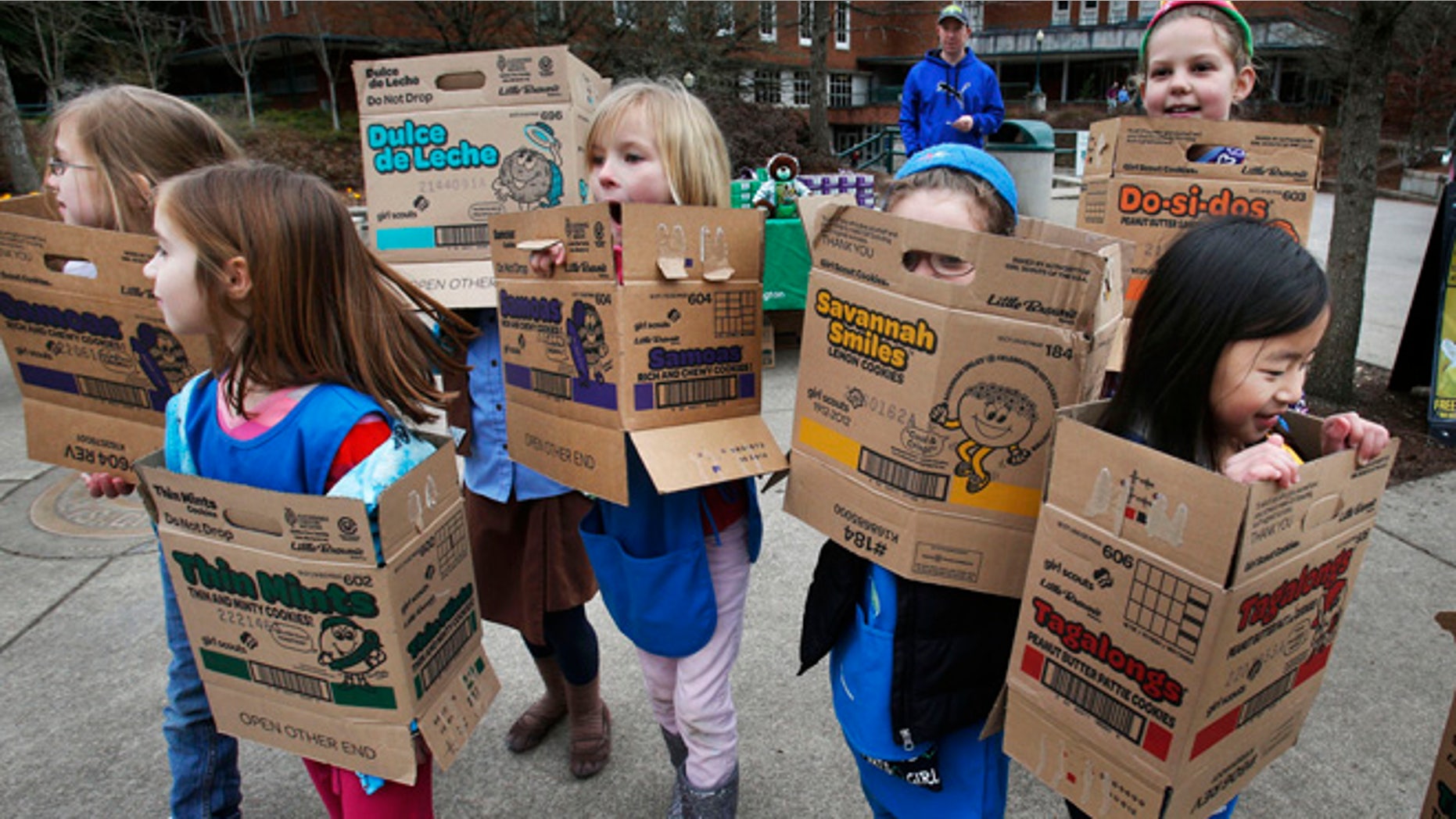 In a Feb. 18, 2013 file photo dressed in boxes emptied from earlier cookie sales, Girl Scouts from Troop 20337 in Eugene fan out on the University of Oregon campus near the Erb Memorial Union in Eugene, Ore., in search of customers for their cookies. Just a year after its 2012 centennial celebrations, the Girl Scouts of the USA's interconnected problems include declining membership and revenues, a dearth of volunteers, rifts between leadership and grass-roots members, a pension plan with a $347 million deficit, and an uproar over efforts by many local councils to sell venerable summer camps.