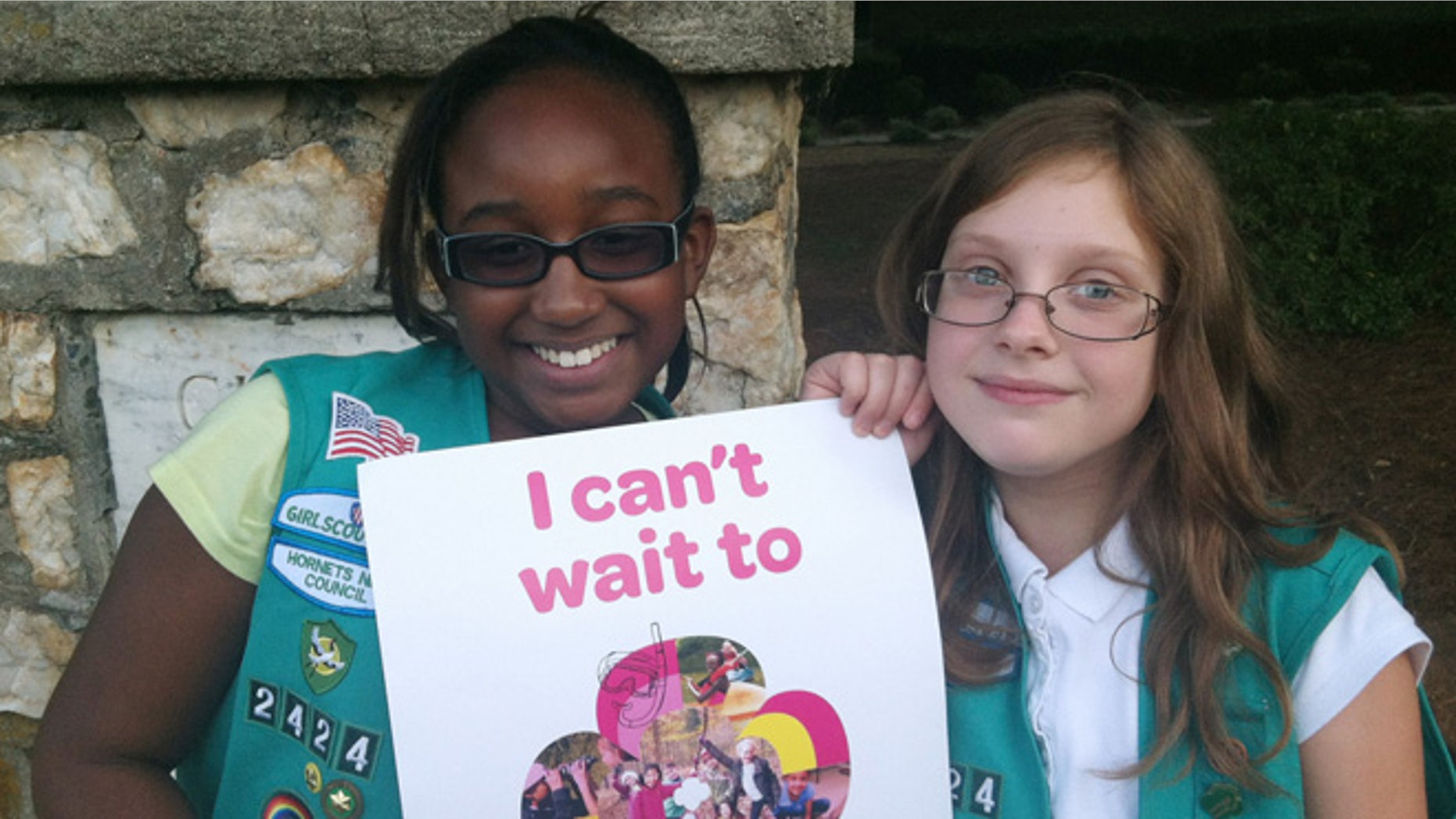 Sept. 27, 2013: In this photo provided by the Girl Scouts, Natalie Harrison, left, and Jasmine Barnett of Troop 2424 hold a promotional poster for their organization outside of Matthews Elementary School in Charlotte, N.C. The fifth graders were volunteering at a Girl Scout Informational night at the school to share their stories about their experiences in the group. Instead of placing ads on TV, in newspapers and on billboards, a decentralized campaign aimed at reversing a long-running decline in participation in the Girl Scouts will unfold in neighborhood initiatives and on social media as local councils directly target elementary school girls - even kindergartners - with promises of adventuresome fun.