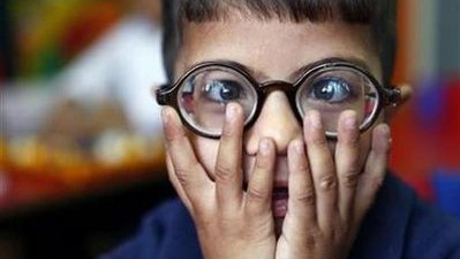 A visually impaired boy wears glasses in this file photo. REUTERS/Yannis Behrakis